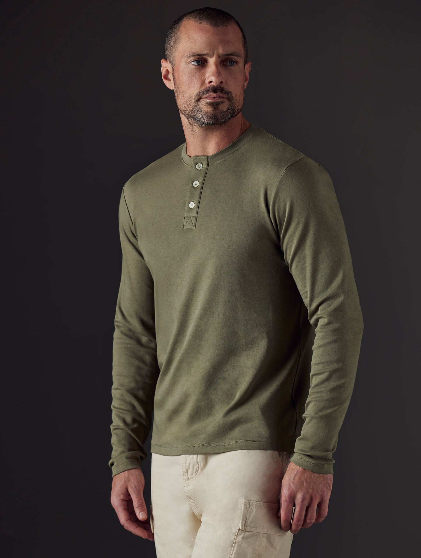 Front 3/4 body view of man wearing Emery Pima Henley in Fern Green from AETHER Apparel.