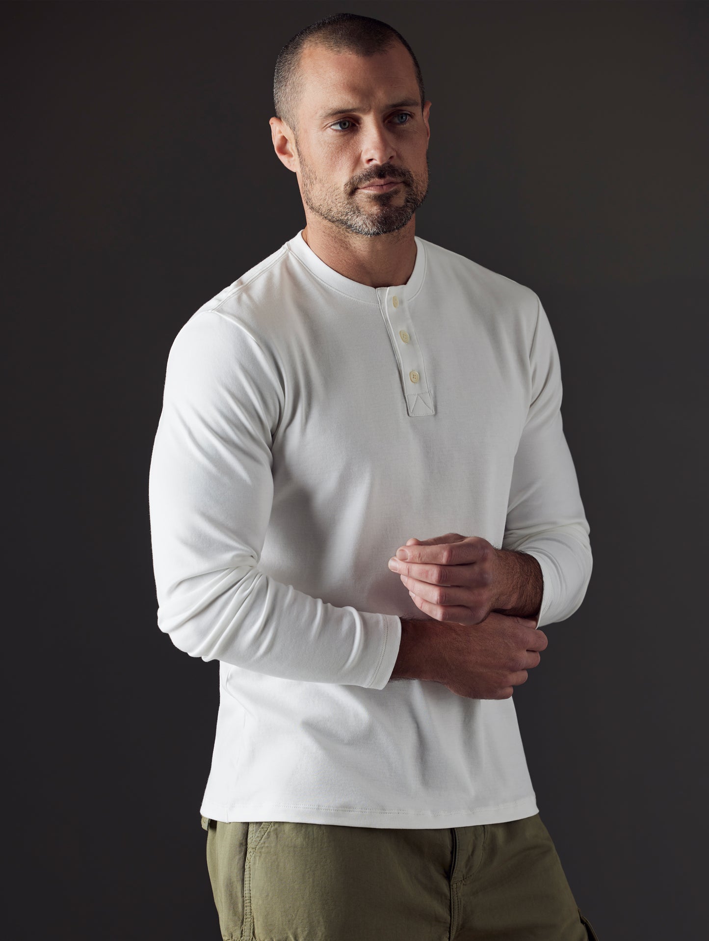 Front 3/4 body view of man wearing Emery Pima Henley in White from AETHER Apparel.