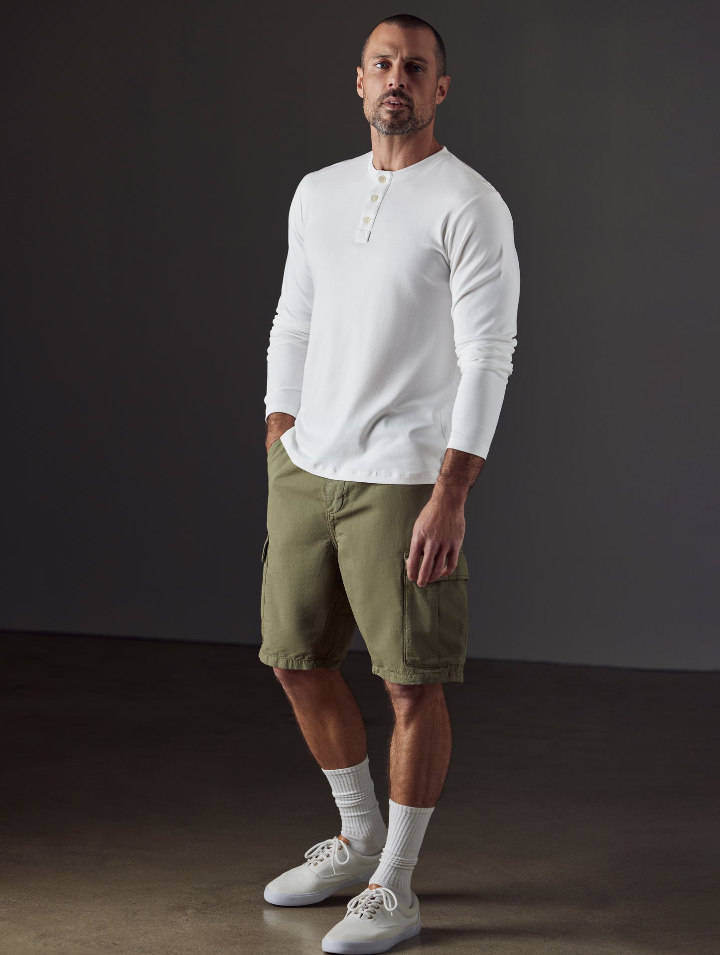 Front 3/4 full-body view of man wearing Emery Pima Henley in White from AETHER Apparel.