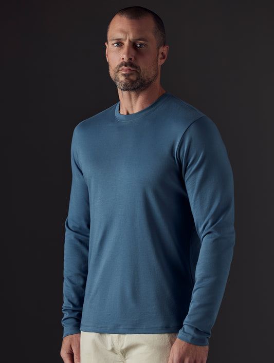 Front body view of man wearing Emery Pima Long-Sleeve Tee in Coastal Blue from AETHER Apparel.