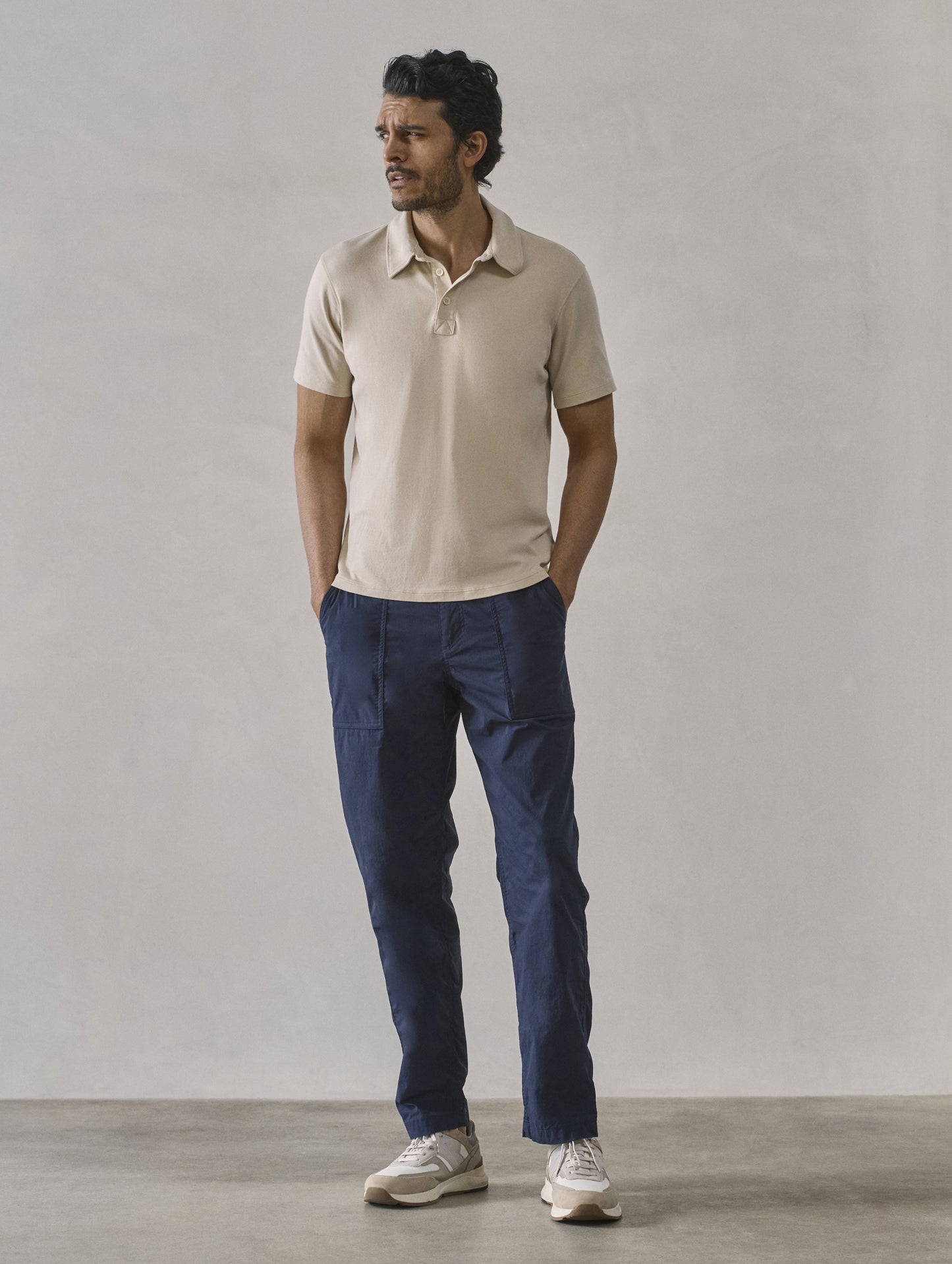Front full-body view of man wearing Emery Pima Polo in Bone white from AETHER Apparel.