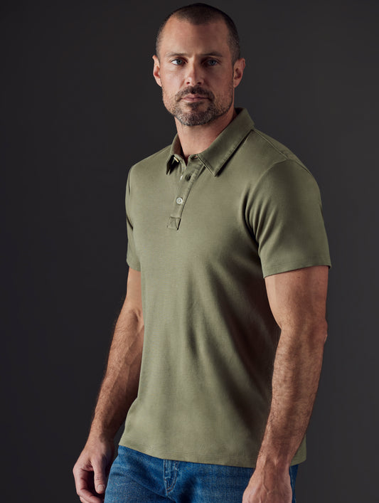 Front 3/4 body view of man wearing Emery Pima Polo in Fern Green from AETHER Apparel.