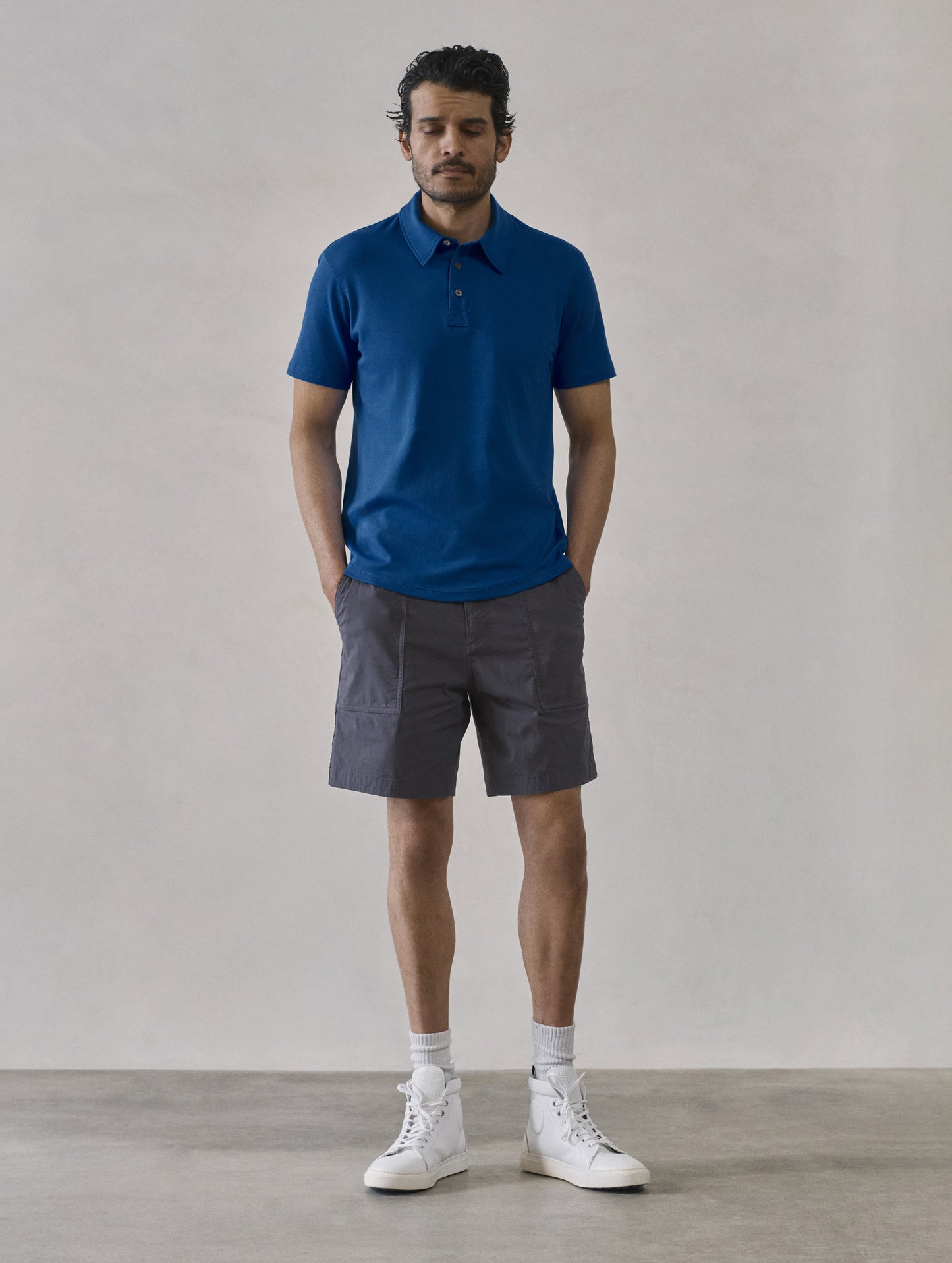 Front full-body view of man wearing Emery Pima Polo in Summit Blue from AETHER Apparel.