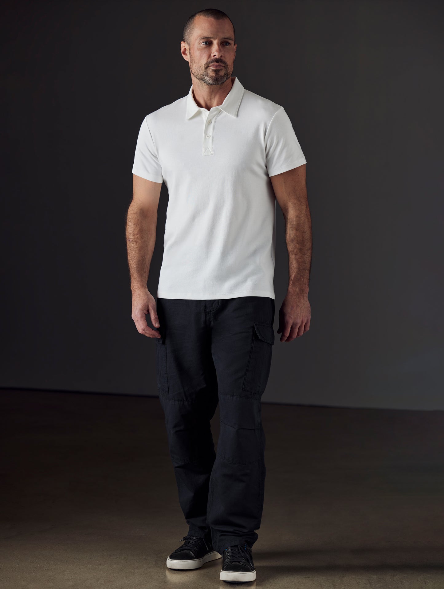 Front full-body view of man wearing Emery Pima Polo in White from AETHER Apparel.
