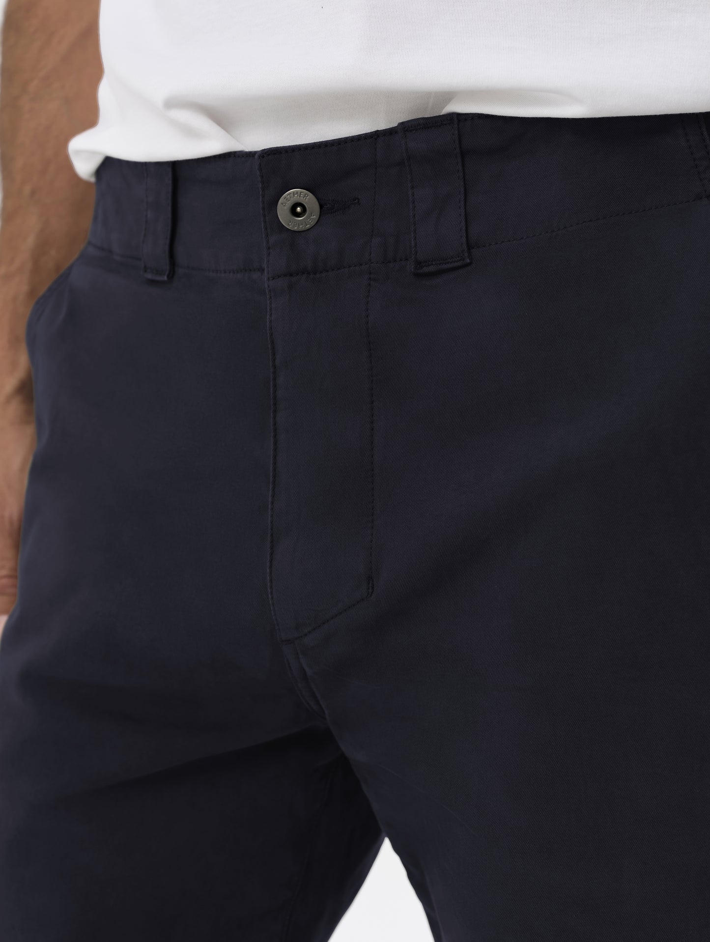Closeup detailed view of the waistband, hand pockets, and main closure on the Flint Chino Pant in Total Eclipse dark blue from AETHER Apparel.