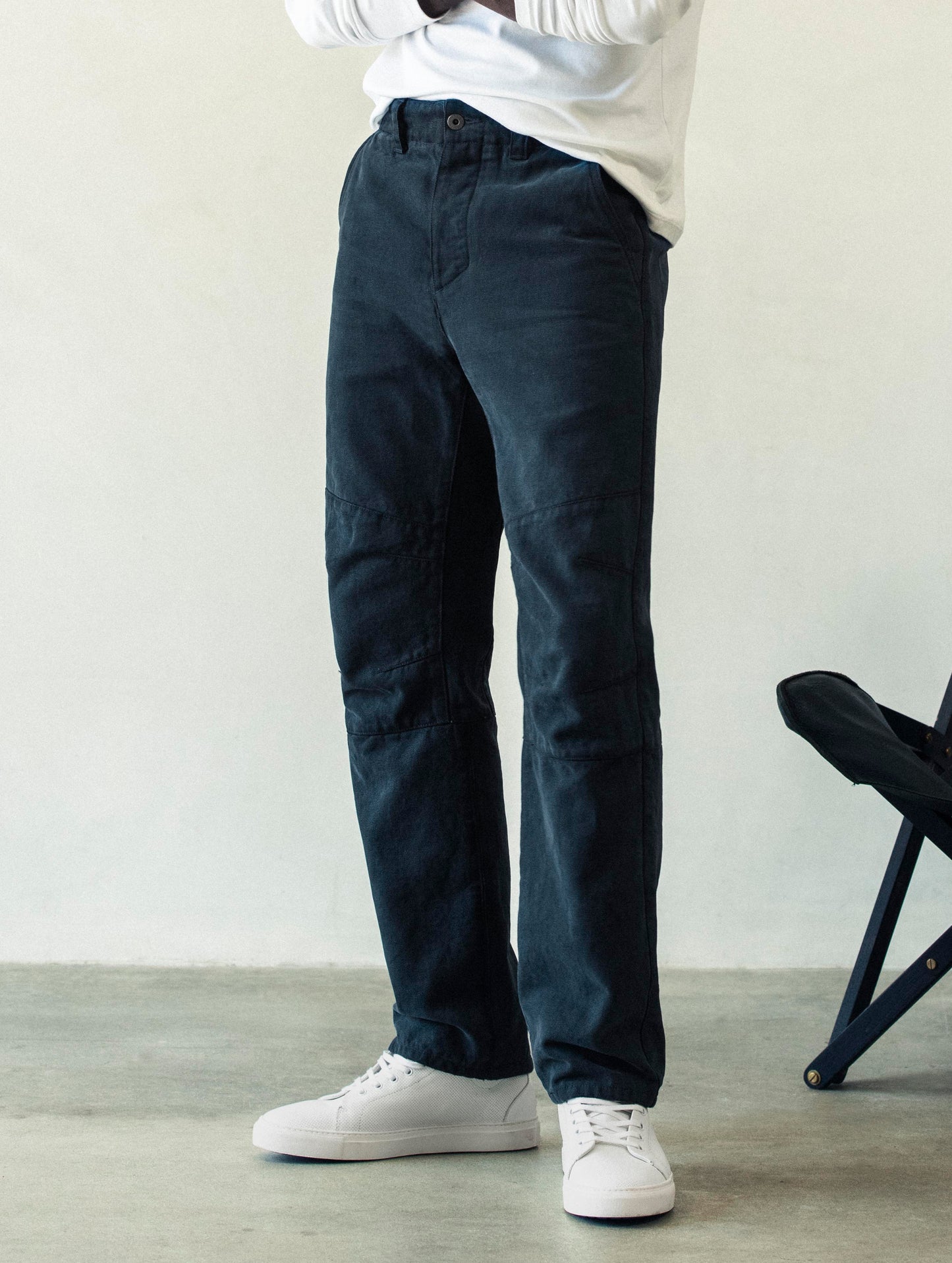 Front angled lower body view of man wearing Gabriel Articulated Chino Stretch pant in Total Eclipse dark blue from AETHER Apparel.