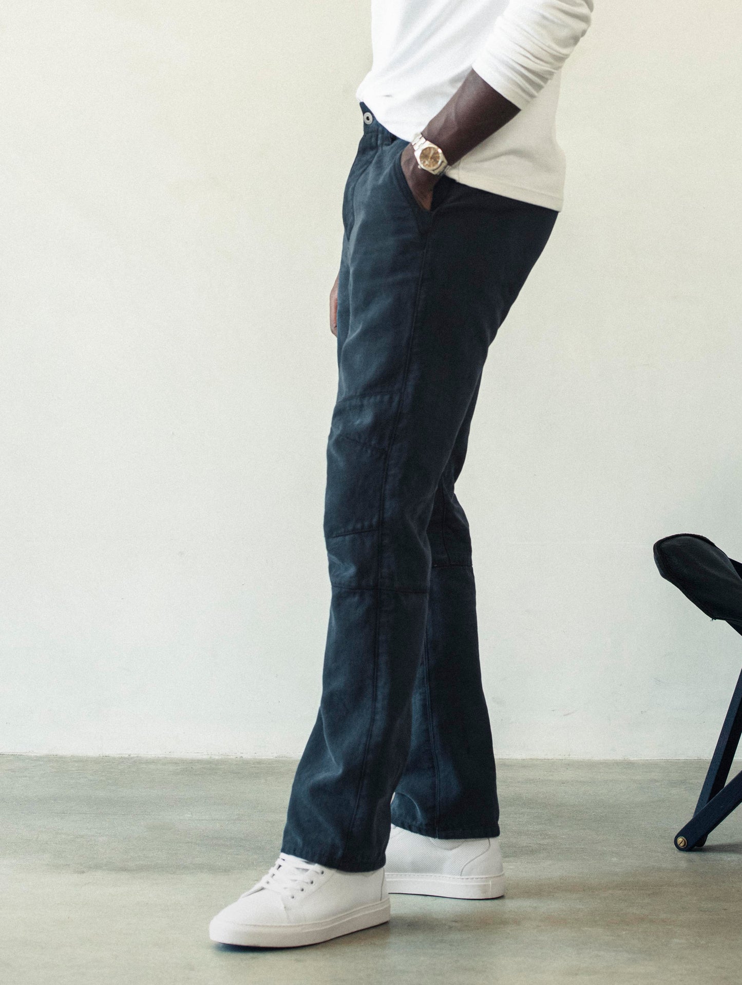 Side profile lower body view of man wearing Gabriel Articulated Chino Stretch pant in Total Eclipse dark blue from AETHER Apparel.
