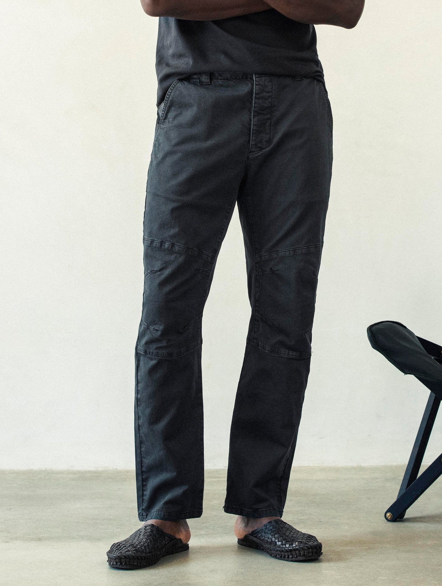 Front lower body view of man wearing Gabriel Articulated Chino Stretch pant in Tarmac Black from AETHER Apparel.