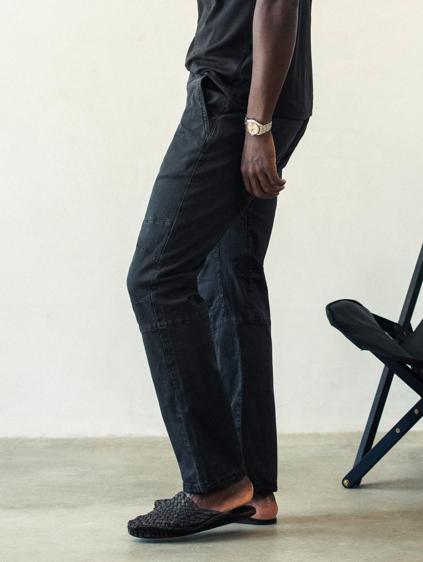 Side profile lower body view of man wearing Gabriel Articulated Chino Stretch pant in Tarmac Black from AETHER Apparel.