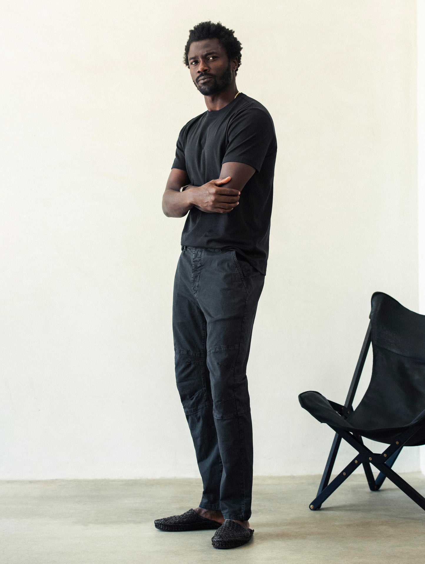 Front angled full-body view of man wearing Gabriel Articulated Chino Stretch pant in Tarmac Black from AETHER Apparel.