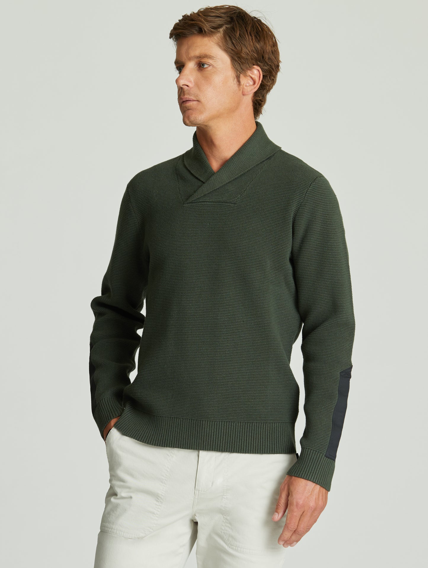 Man wearing green Gamma Sweater from AETHER Apparel.