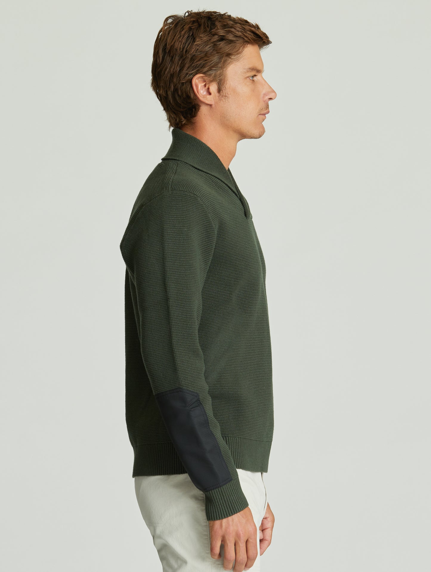Side view of man wearing green Gamma Sweater from AETHER Apparel.