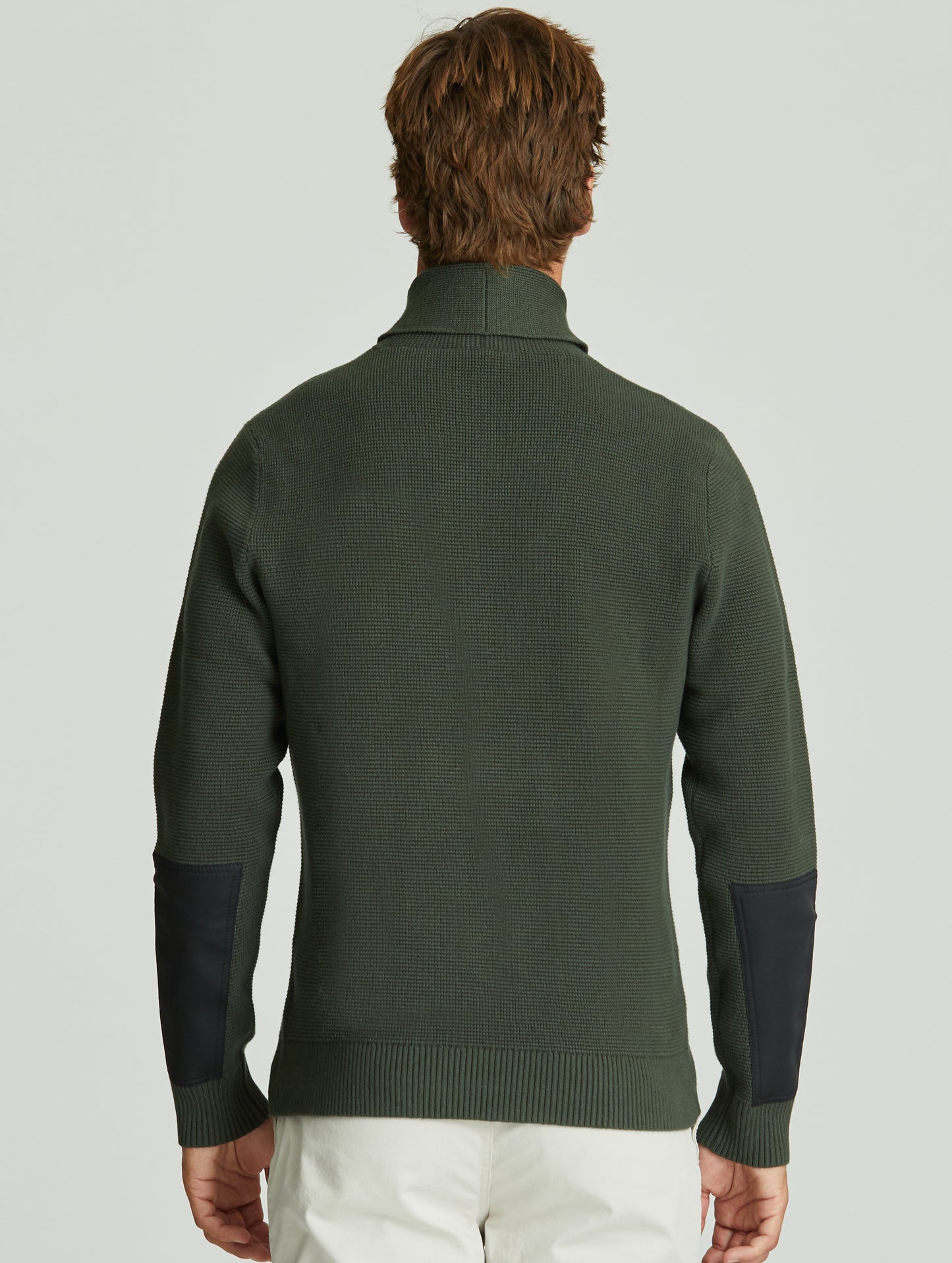 Back view of man wearing green Gamma Sweater from AETHER Apparel.