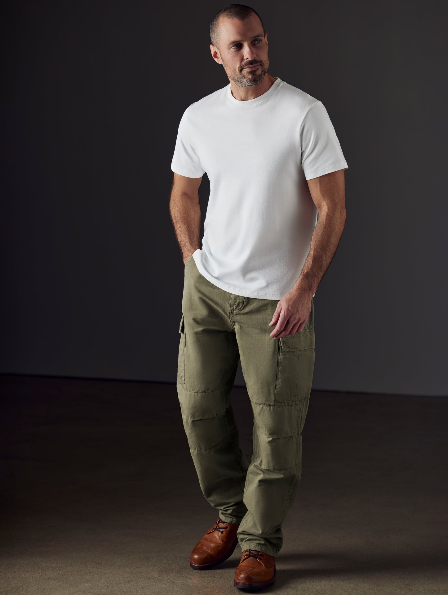 Front 3/4 full-body view of man wearing Glade Fatigue Pant in Fern Green from AETHER Apparel.
