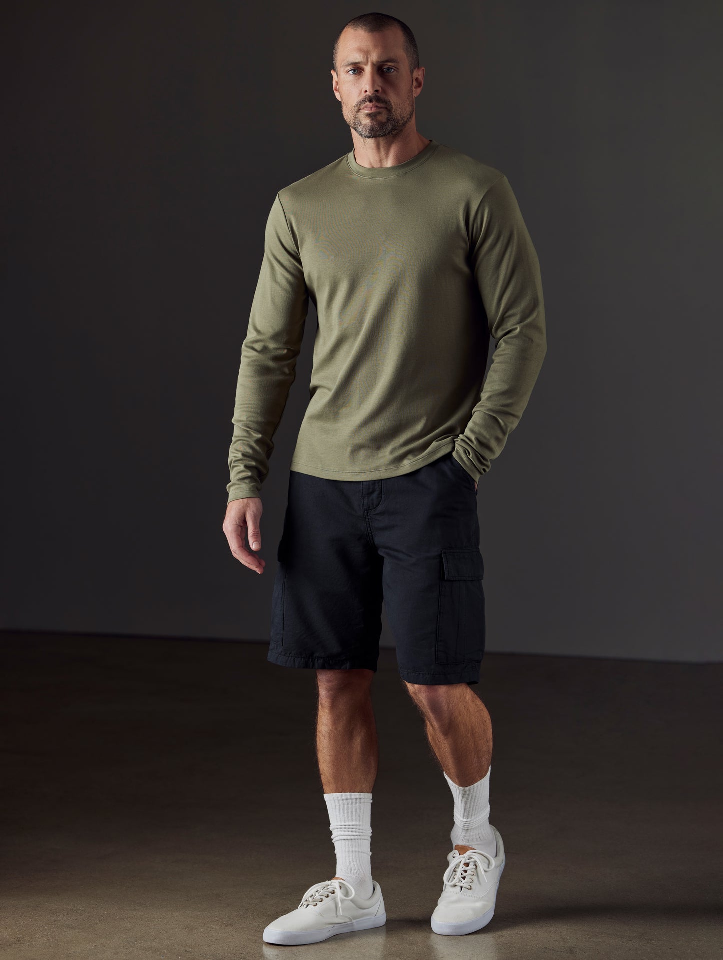 Front 3/4 full-body view of man wearing Glade Fatigue Short in Onyx Black from AETHER Apparel.