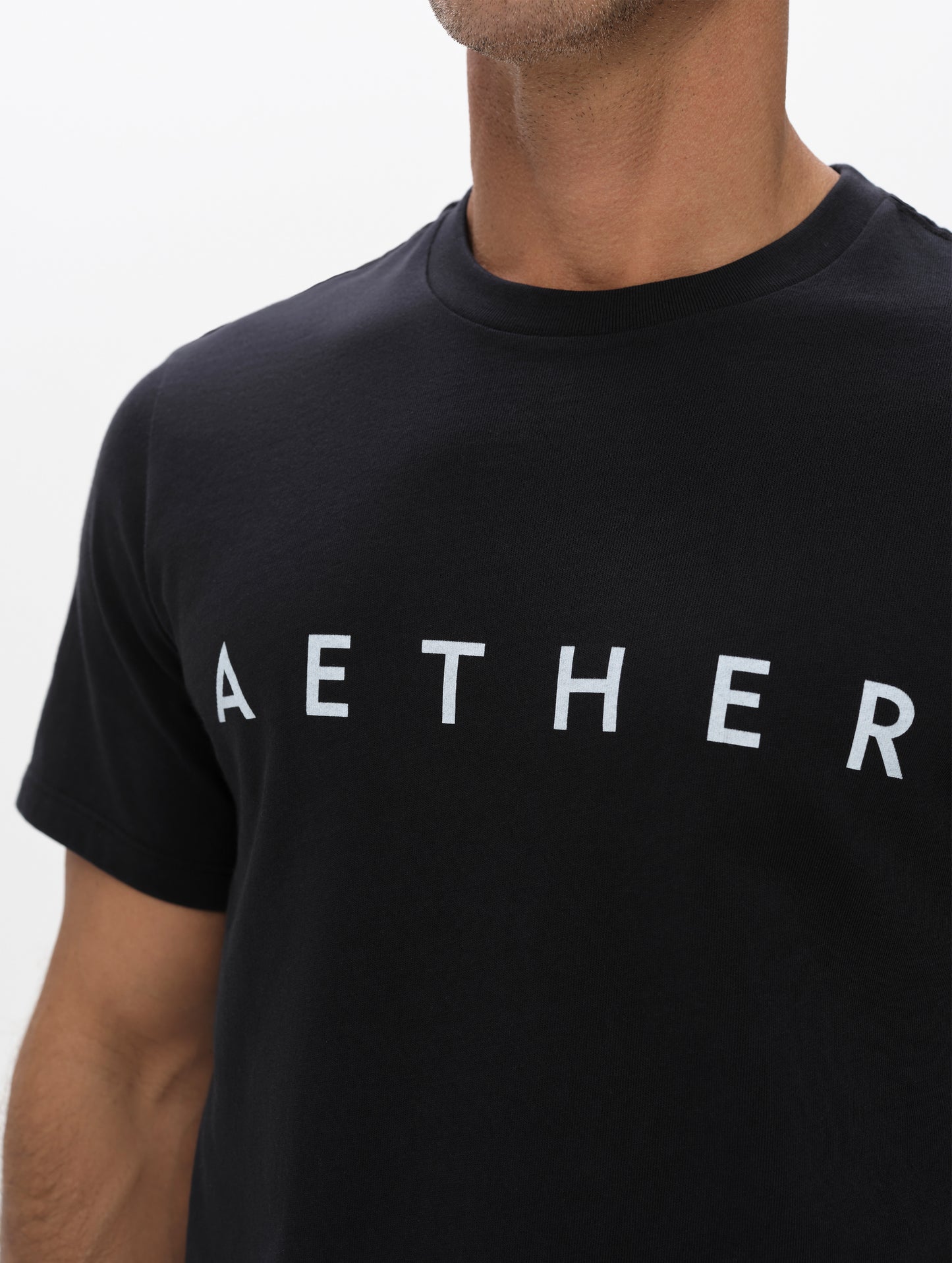 Closeup view of the screen-printed AETHER logo on the Graphic Tee AETHER Logo in Onyx Black from AETHER Apparel.