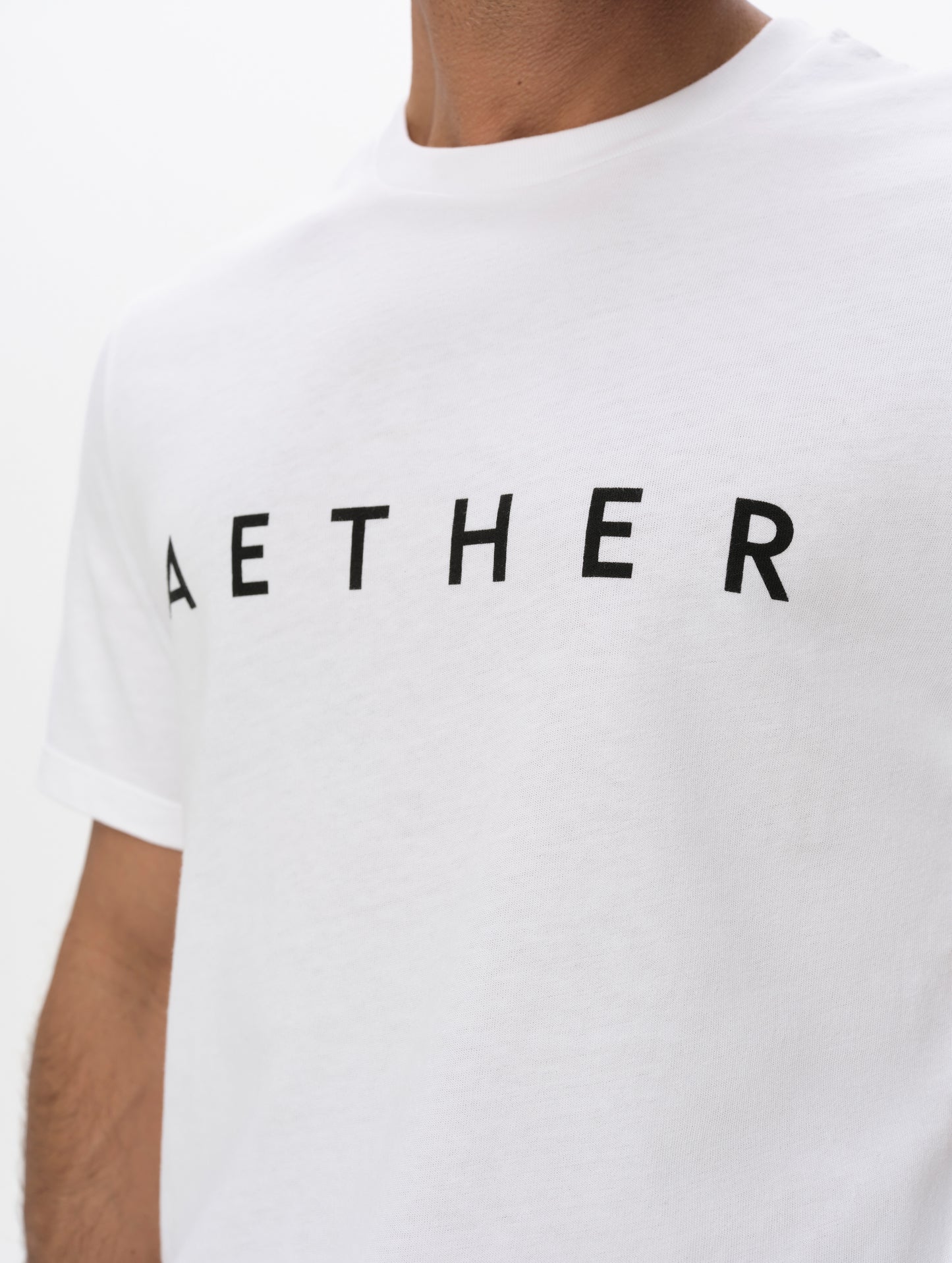 Closeup view of the screen-printed AETHER logo on the Graphic Tee AETHER Logo in White from AETHER Apparel.