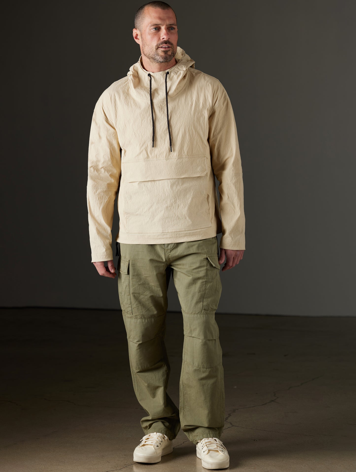 Front full-body view of man wearing Harrier Anorak in Desert Tan from AETHER Apparel.