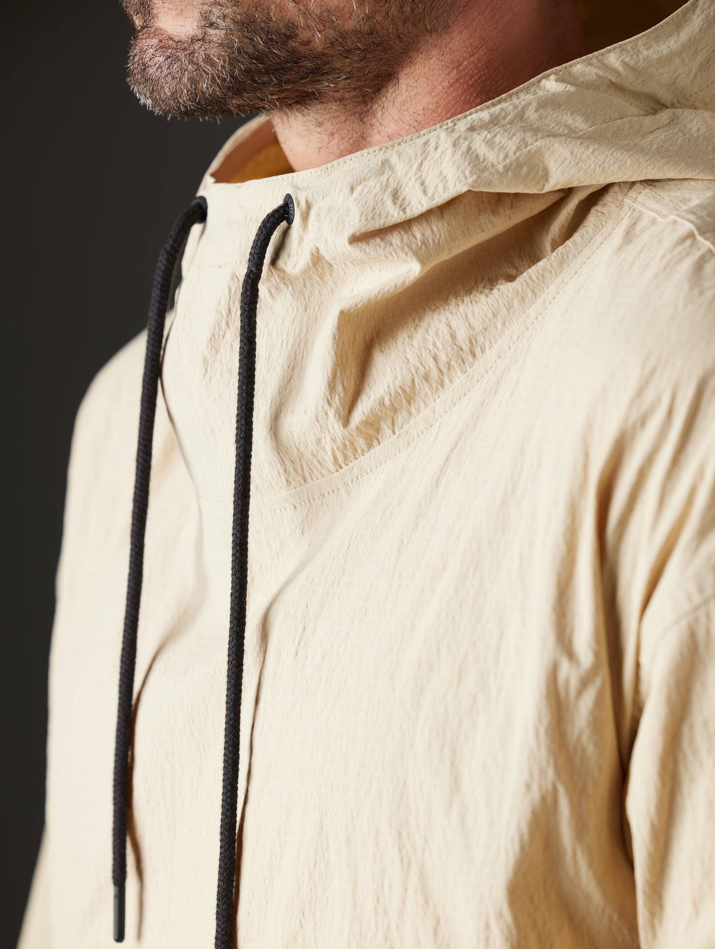 Detailed view of drawstrings and hood of Harrier Anorak in Desert Tan from AETHER Apparel.