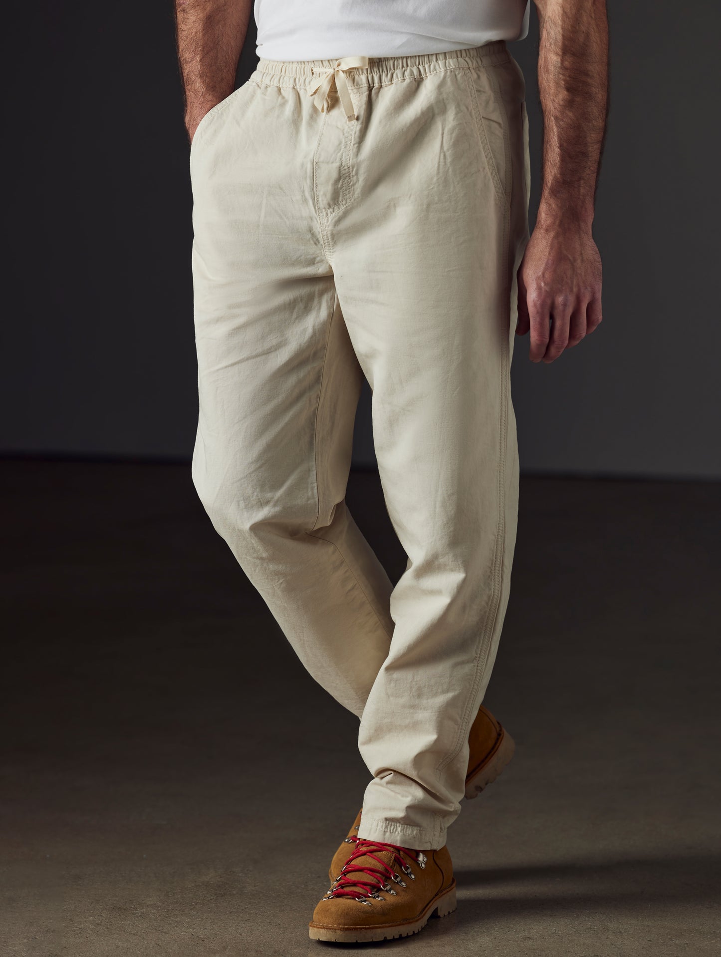 Front 3/4 lower body view of man wearing Highland Drawstring Pant in Bone White from AETHER Apparel.