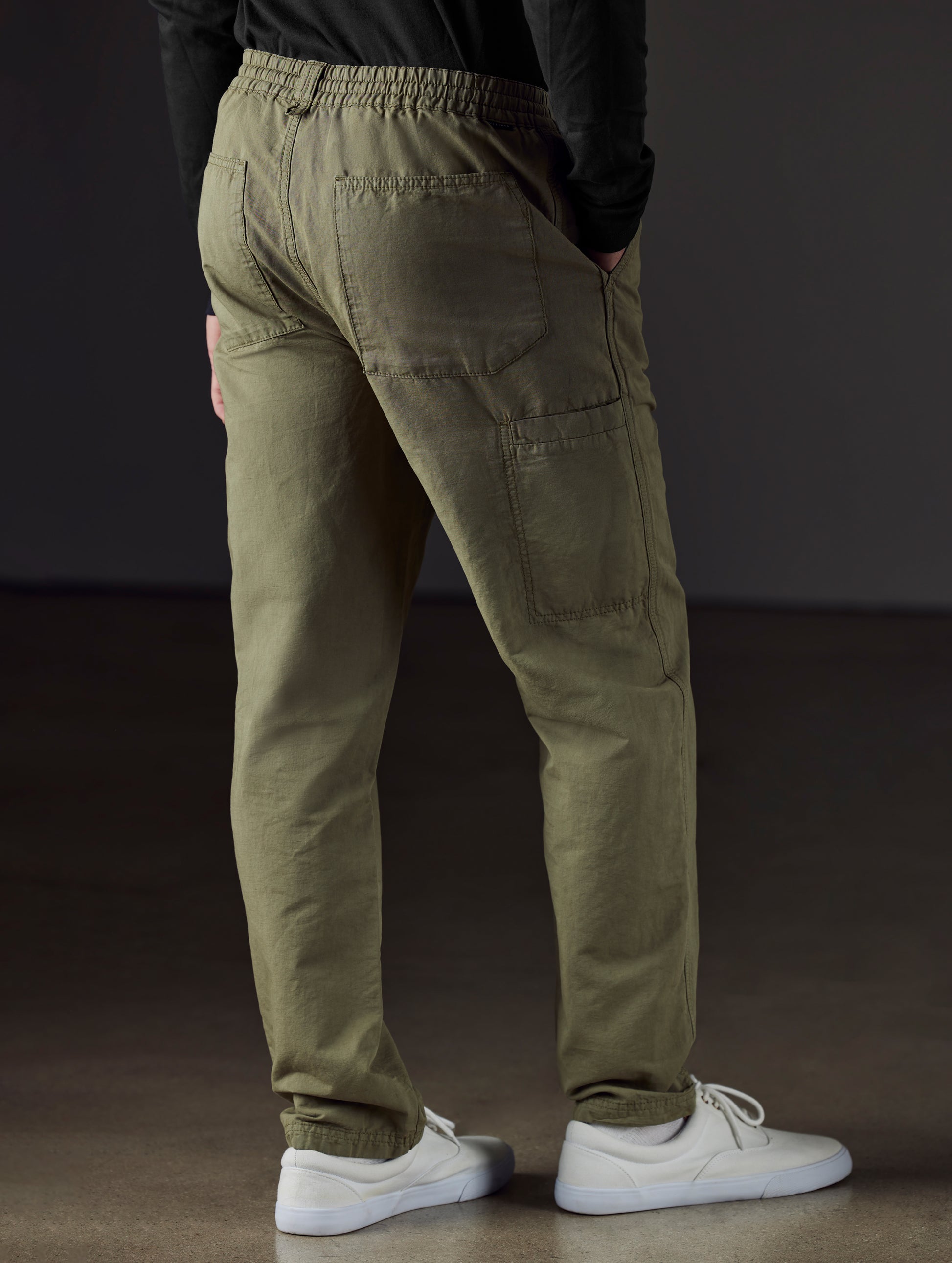 Rear 3/4 lower body view of man wearing Highland Drawstring Pant in Fern Green from AETHER Apparel.