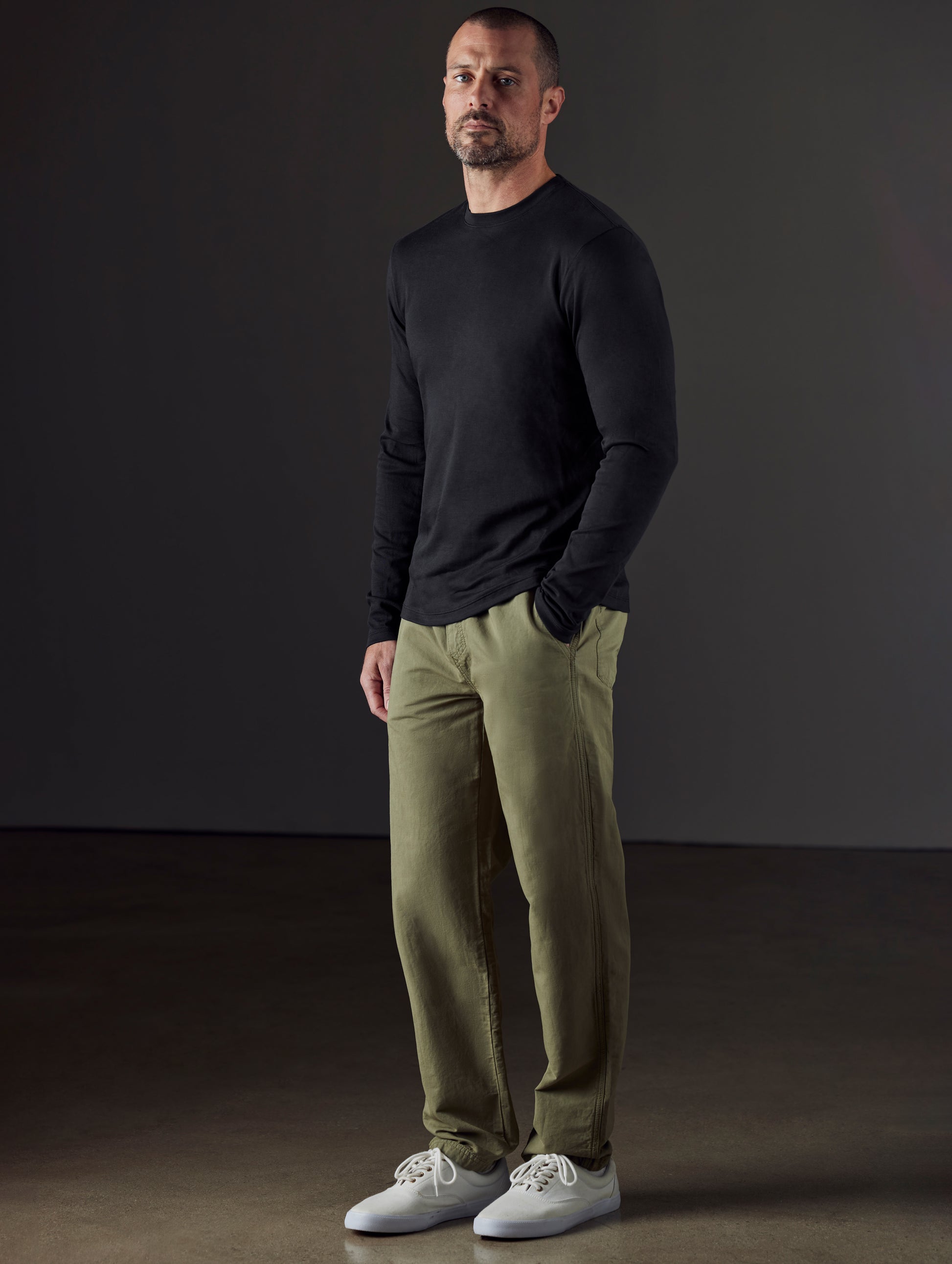 Front 3/4 full-body view of man wearing Highland Drawstring Pant in Fern Green from AETHER Apparel.