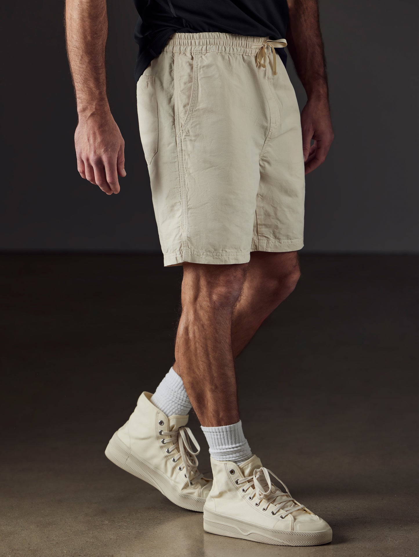 Front 3/4 lower body view of man wearing Highland Drawstring Short in Bone white from AETHER Apparel.