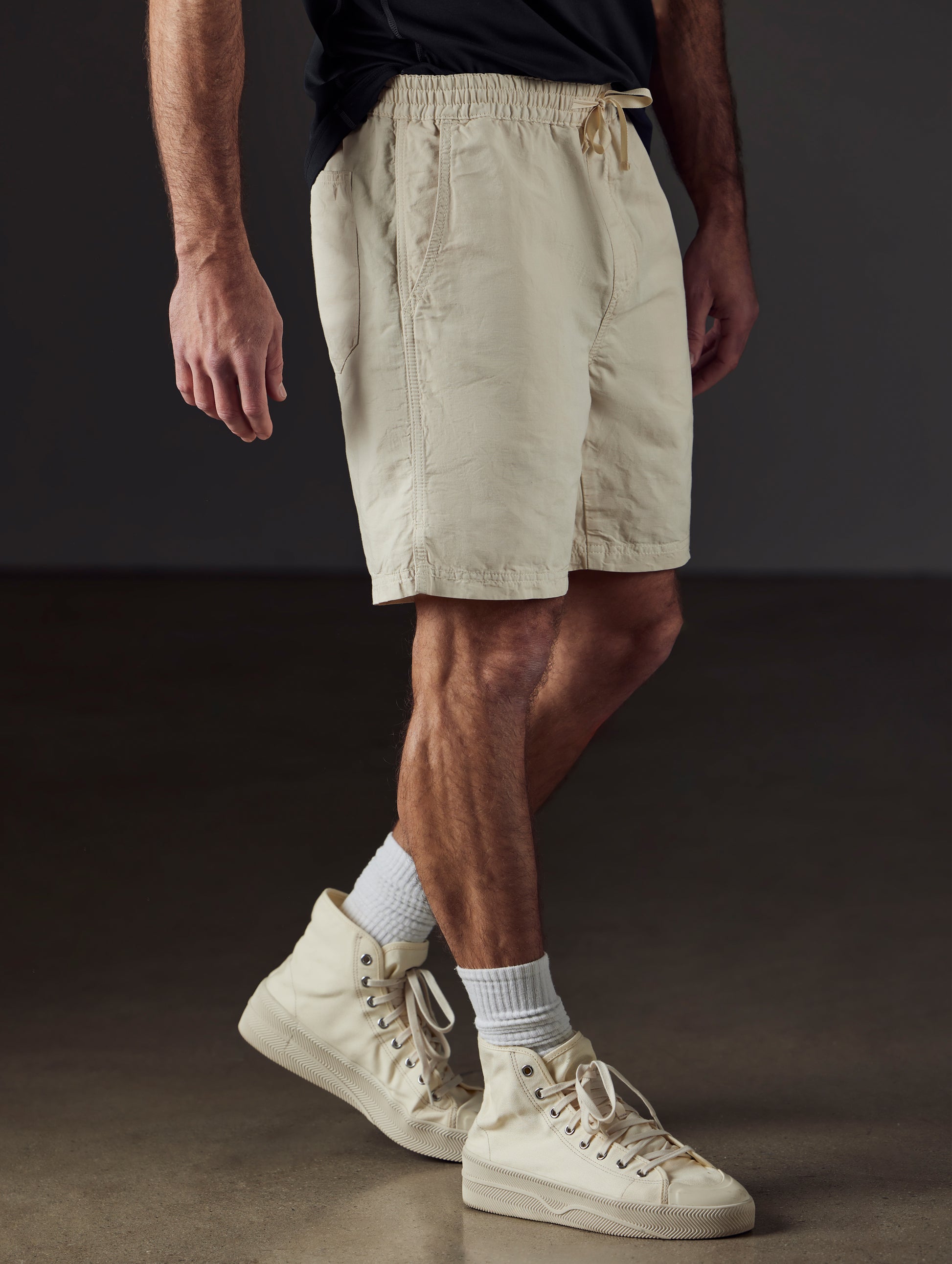 Front 3/4 lower body view of man wearing Highland Drawstring Short in Bone white from AETHER Apparel.