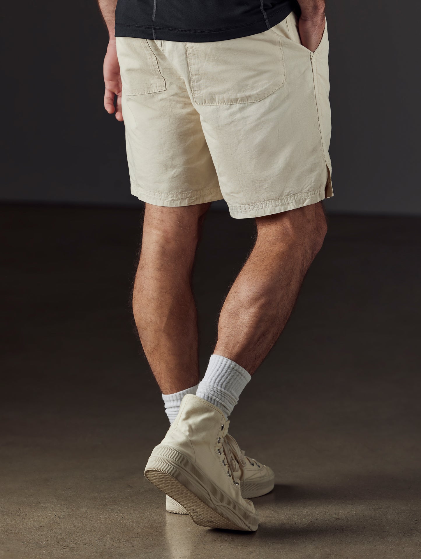Rear 3/4 lower body view of man wearing Highland Drawstring Short in Bone white from AETHER Apparel.