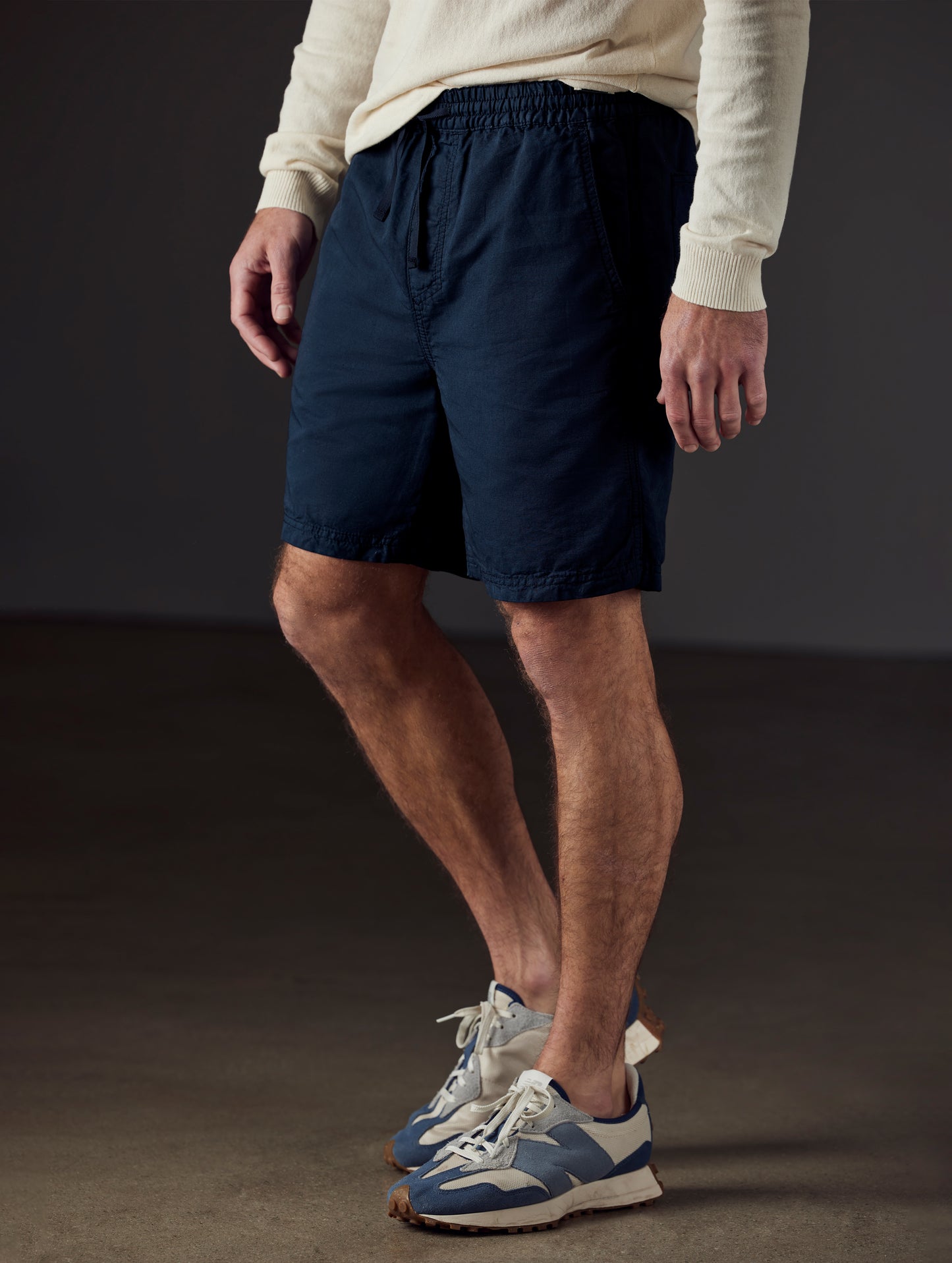 Front 3/4 lower body view of man wearing Highland Drawstring Short in Total Eclipse dark blue from AETHER Apparel.