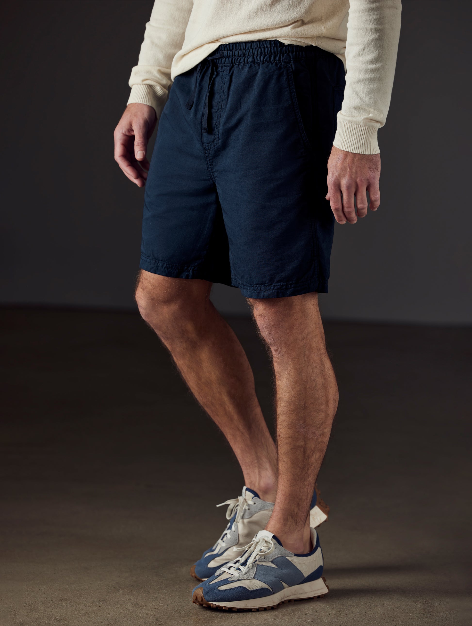 Front 3/4 lower body view of man wearing Highland Drawstring Short in Total Eclipse dark blue from AETHER Apparel.