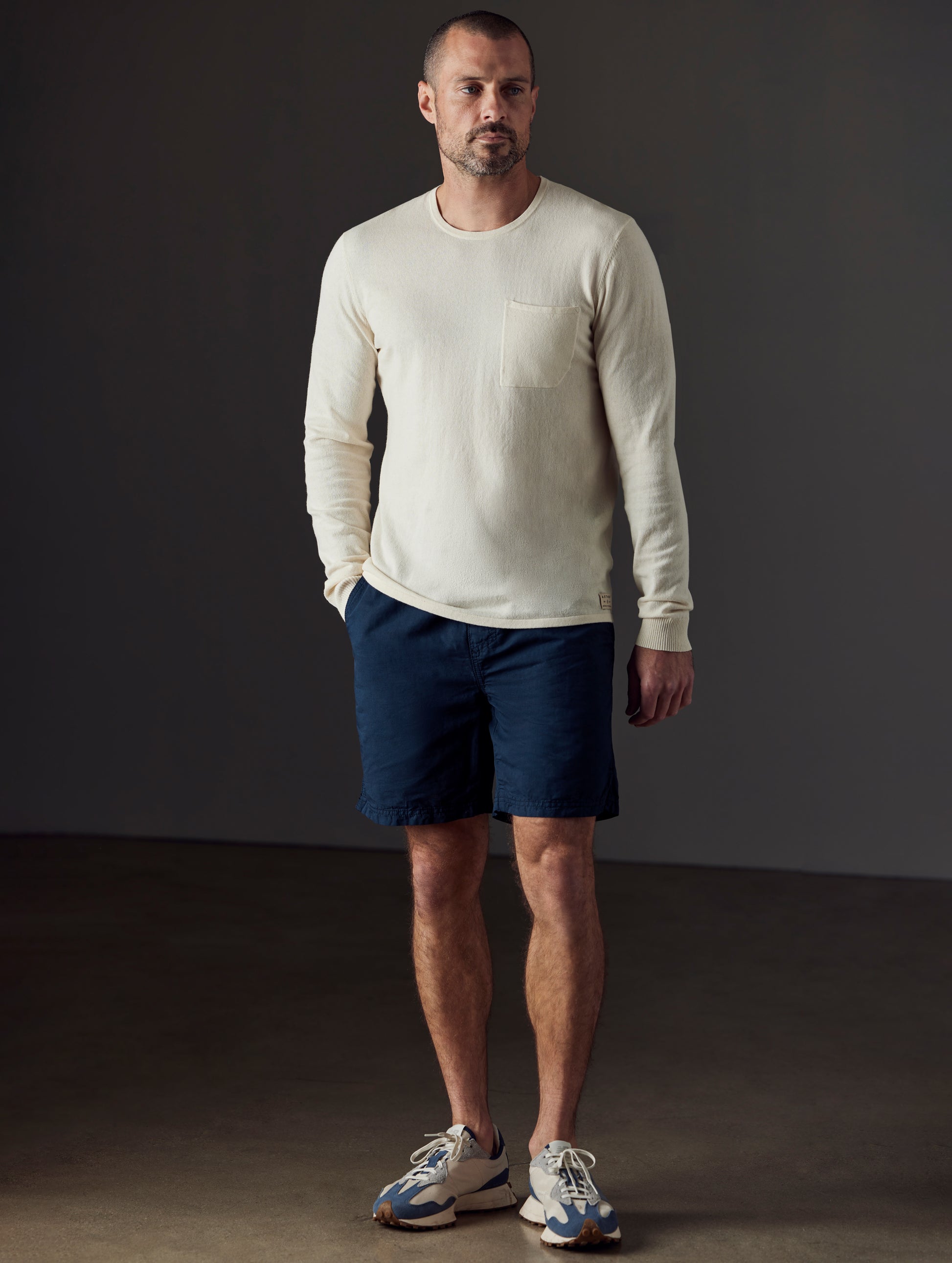 Front full-body view of man wearing Highland Drawstring Short in Total Eclipse dark blue from AETHER Apparel.