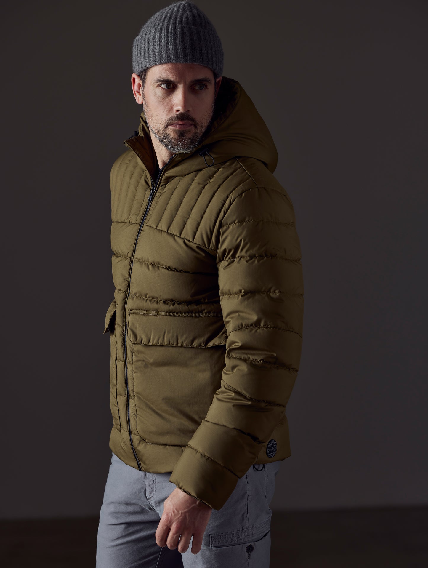 Front 3/4 body view of man wearing Hudson Down Jacket in Command Green from AETHER Apparel.