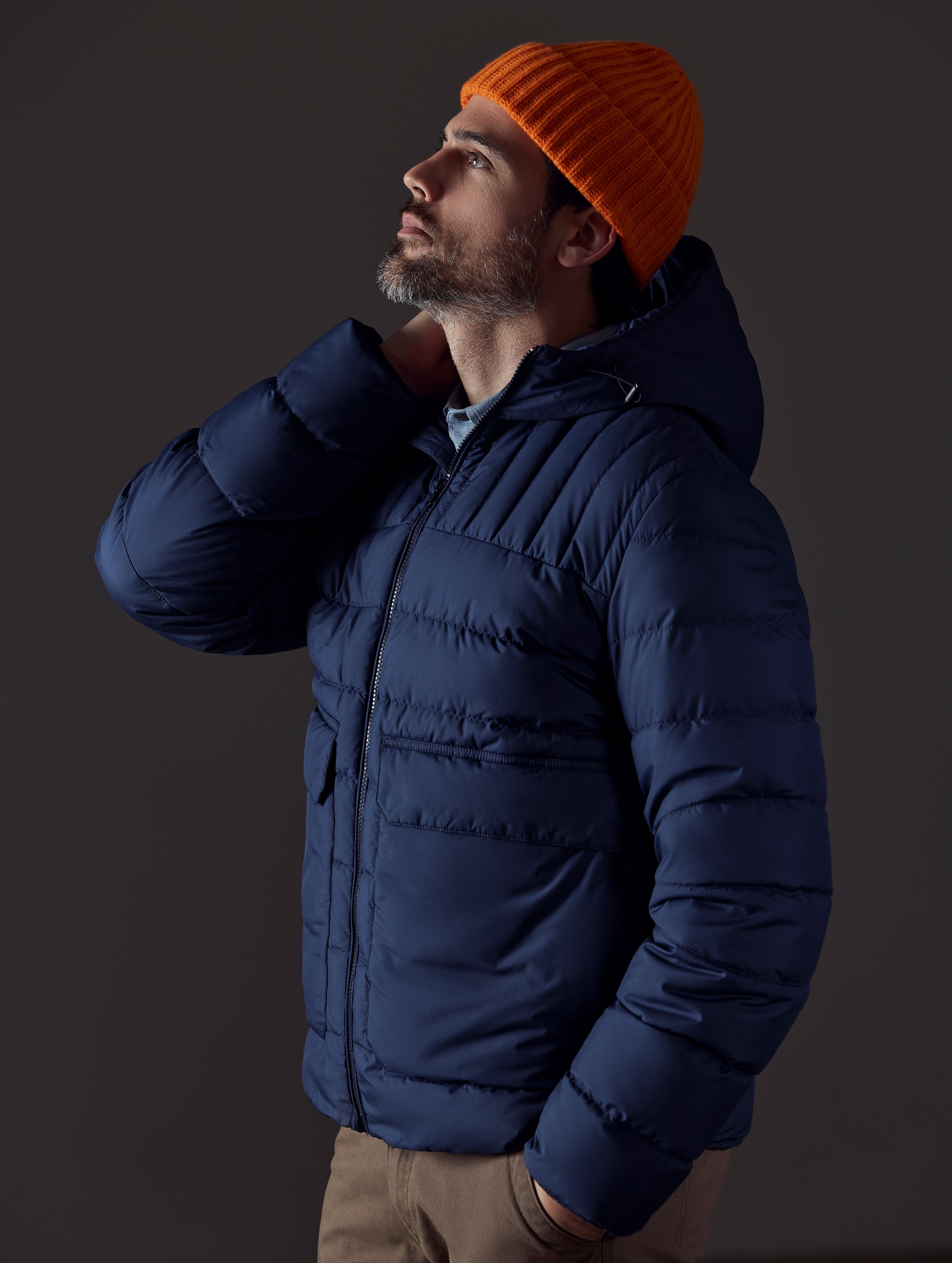 Front 3/4 body view of man wearing Hudson Down Jacket in Total Eclipse dark blue from AETHER Apparel.