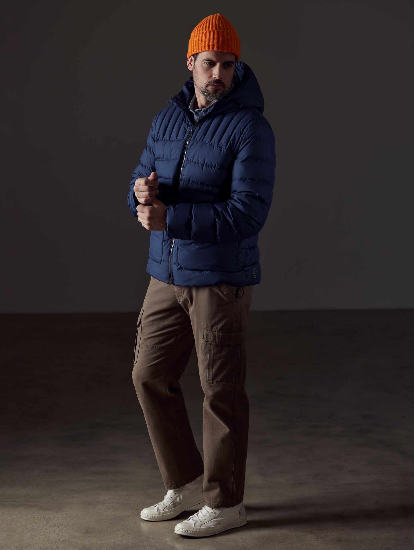 Front 3/4 full-body view of man wearing Hudson Down Jacket in Total Eclipse dark blue from AETHER Apparel.