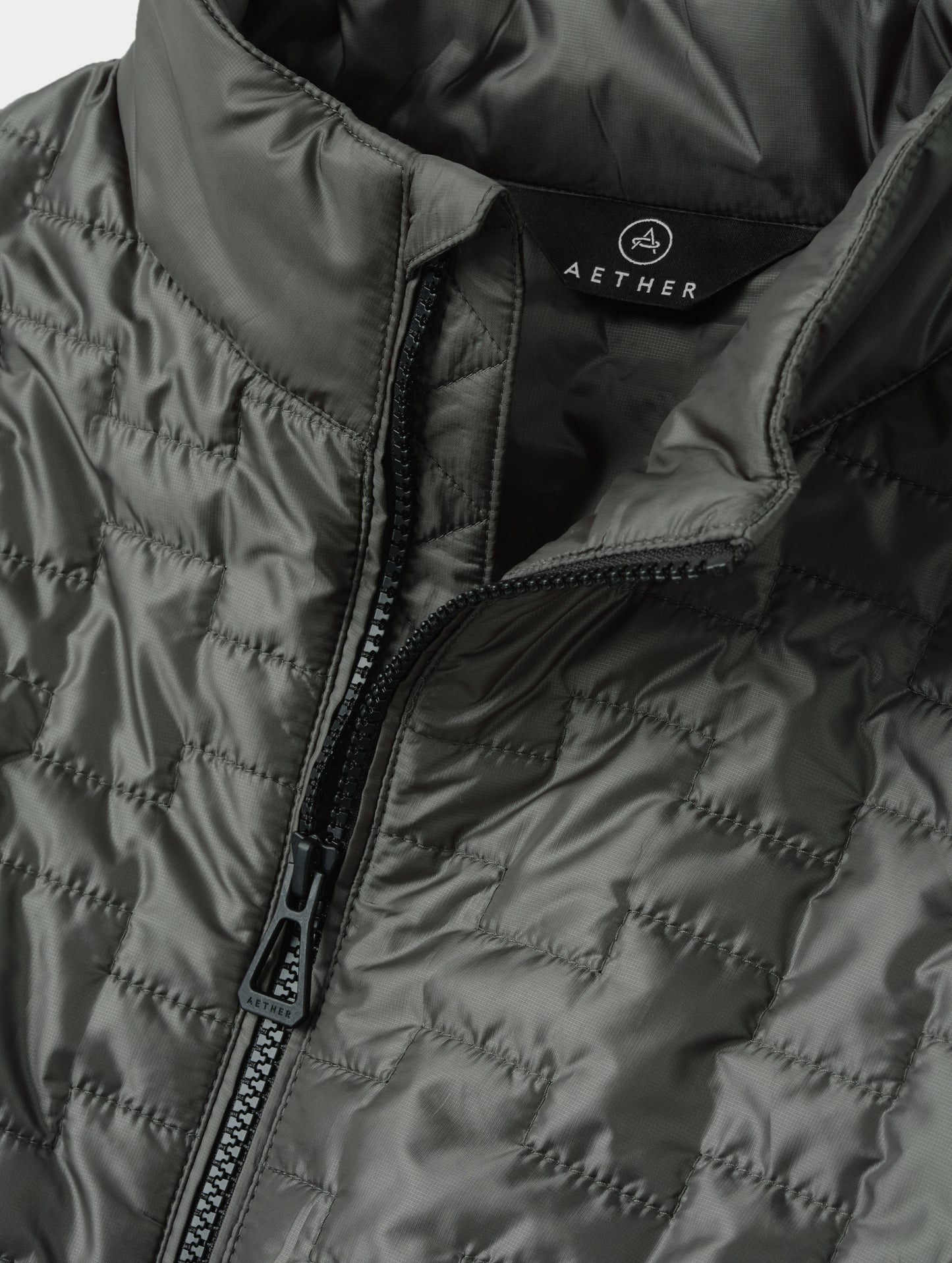 Closeup detailed view of the main center-front zipper on the Hybrid Tech Full-Zip 2.0 in Saville Green from AETHER Apparel.