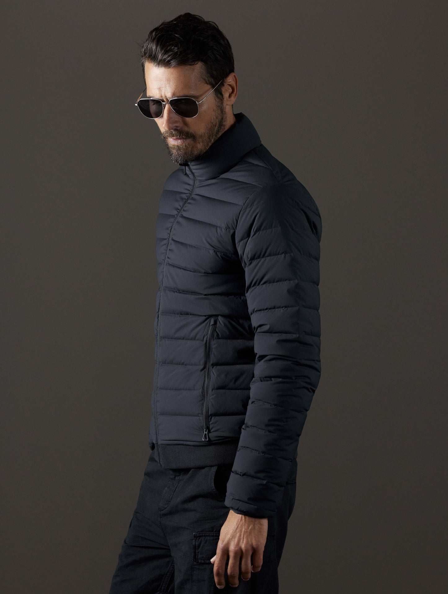 Side profile body view of man wearing Launch Full-Zip Jacket NH in Onyx Black from AETHER Apparel.