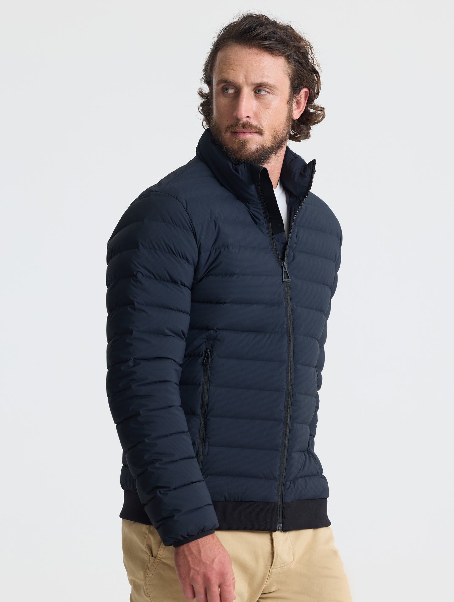 Angled view of man wearing Launch Jacket in Onyx Black from AETHER Apparel.