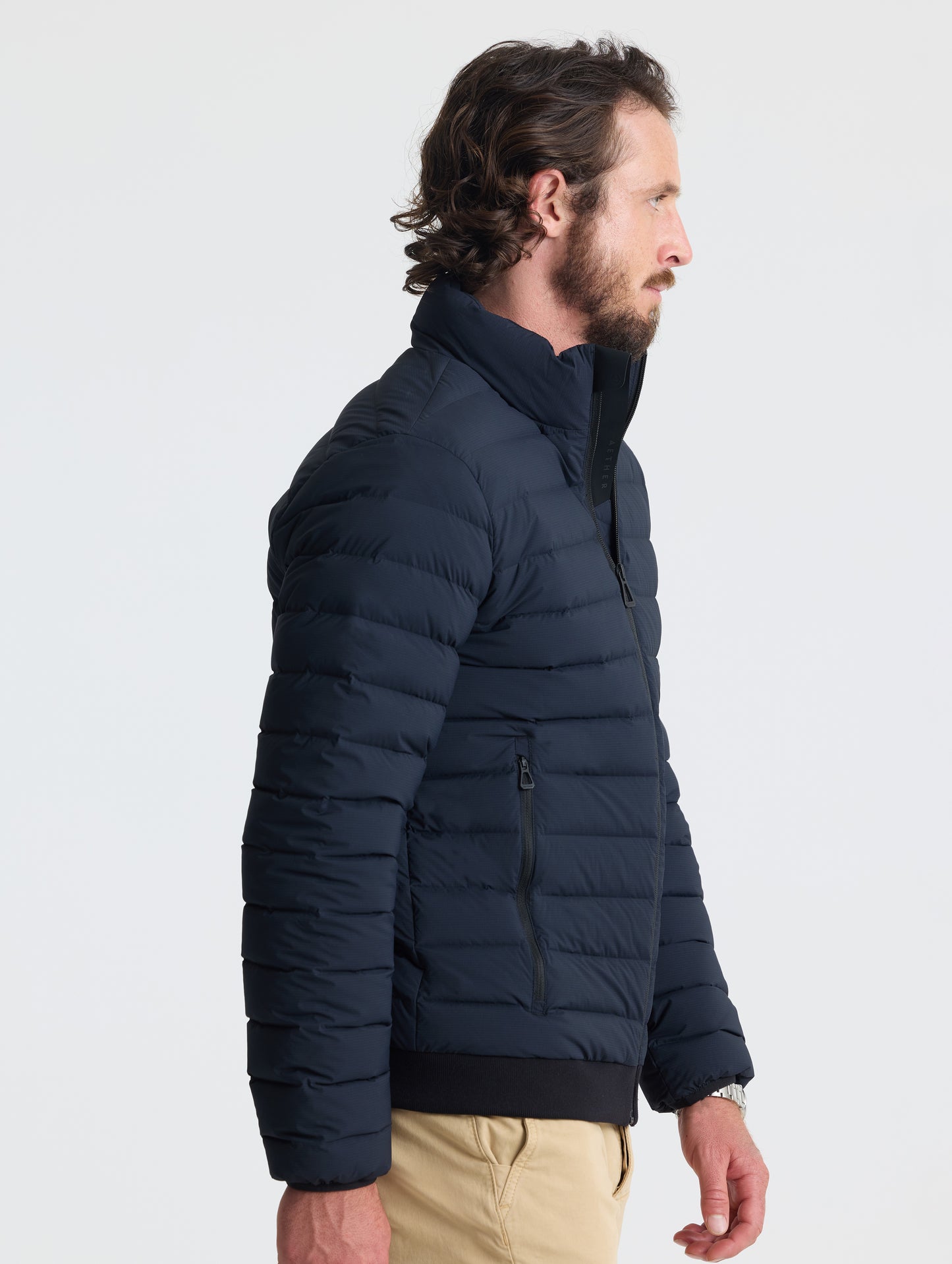 Right profile view of man wearing Launch Jacket in Onyx Black from AETHER Apparel.