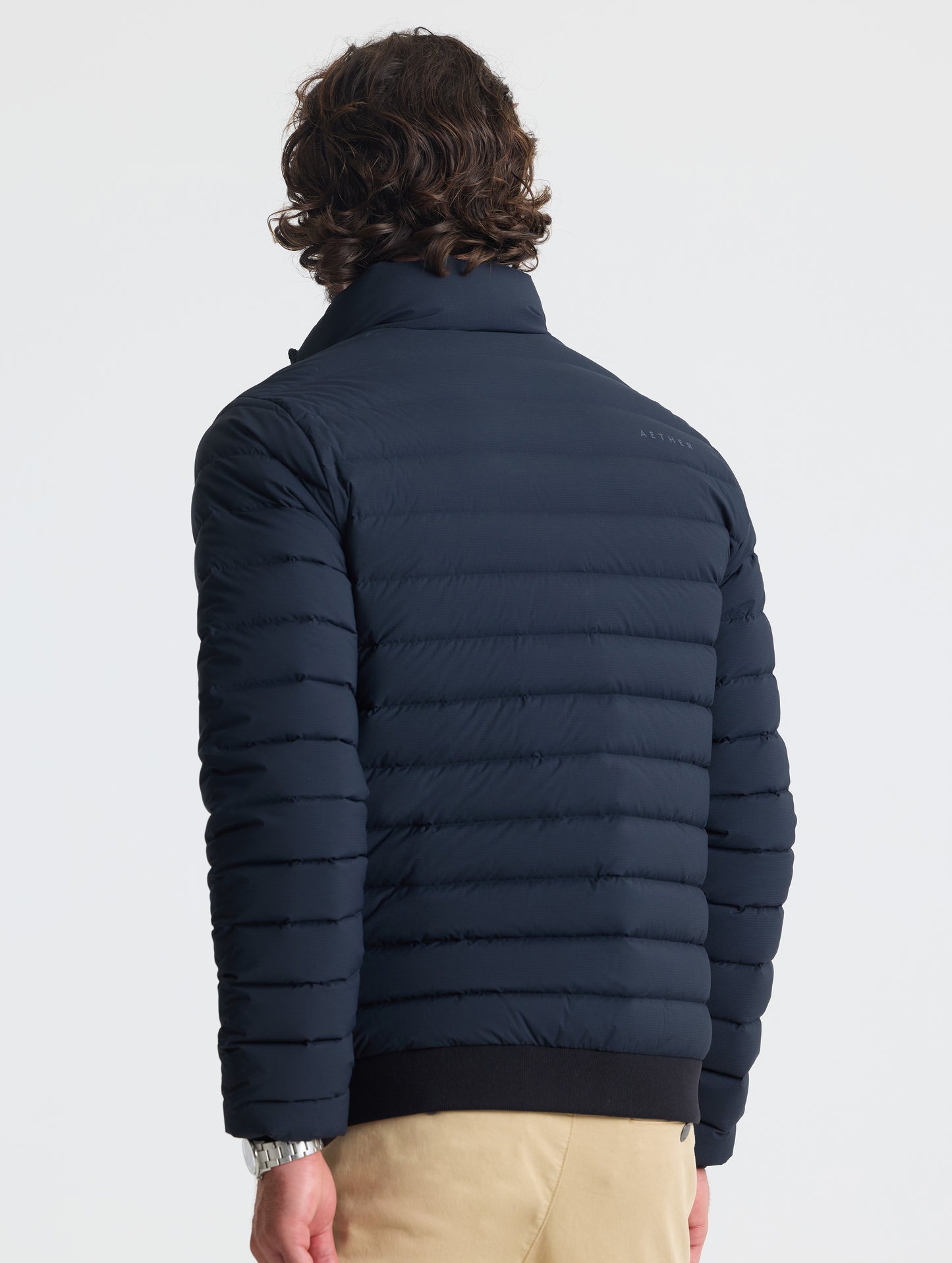 Rear view of man wearing Launch Jacket in Onyx Black from AETHER Apparel.