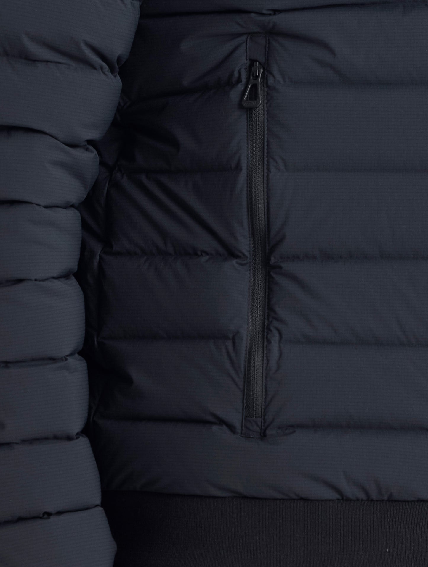 Closeup view of wearer's right zipper hand pocket of Launch Jacket in Onyx Black from AETHER Apparel.