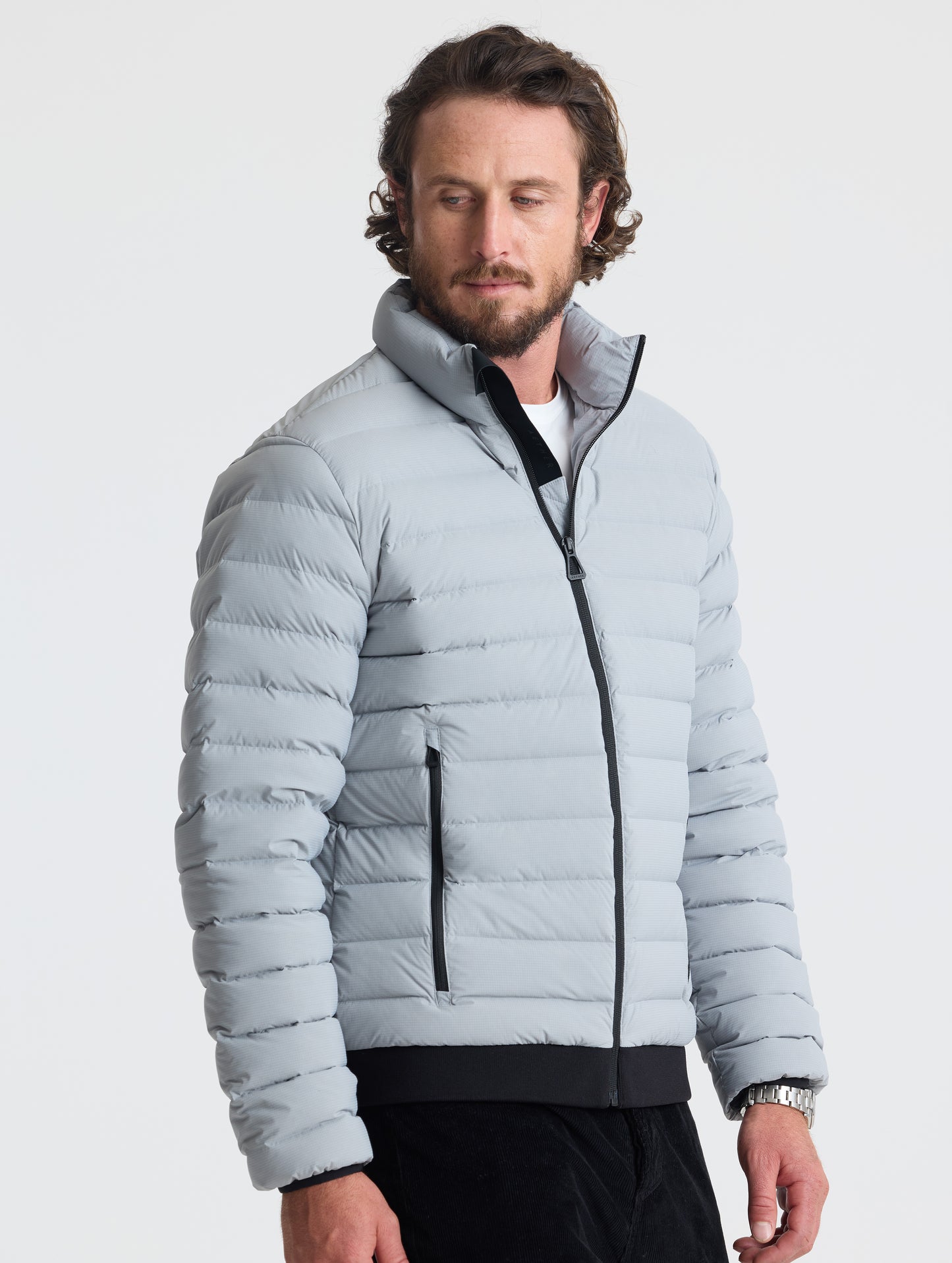 Angled view of man wearing Launch Jacket in Sky Grey from AETHER Apparel.