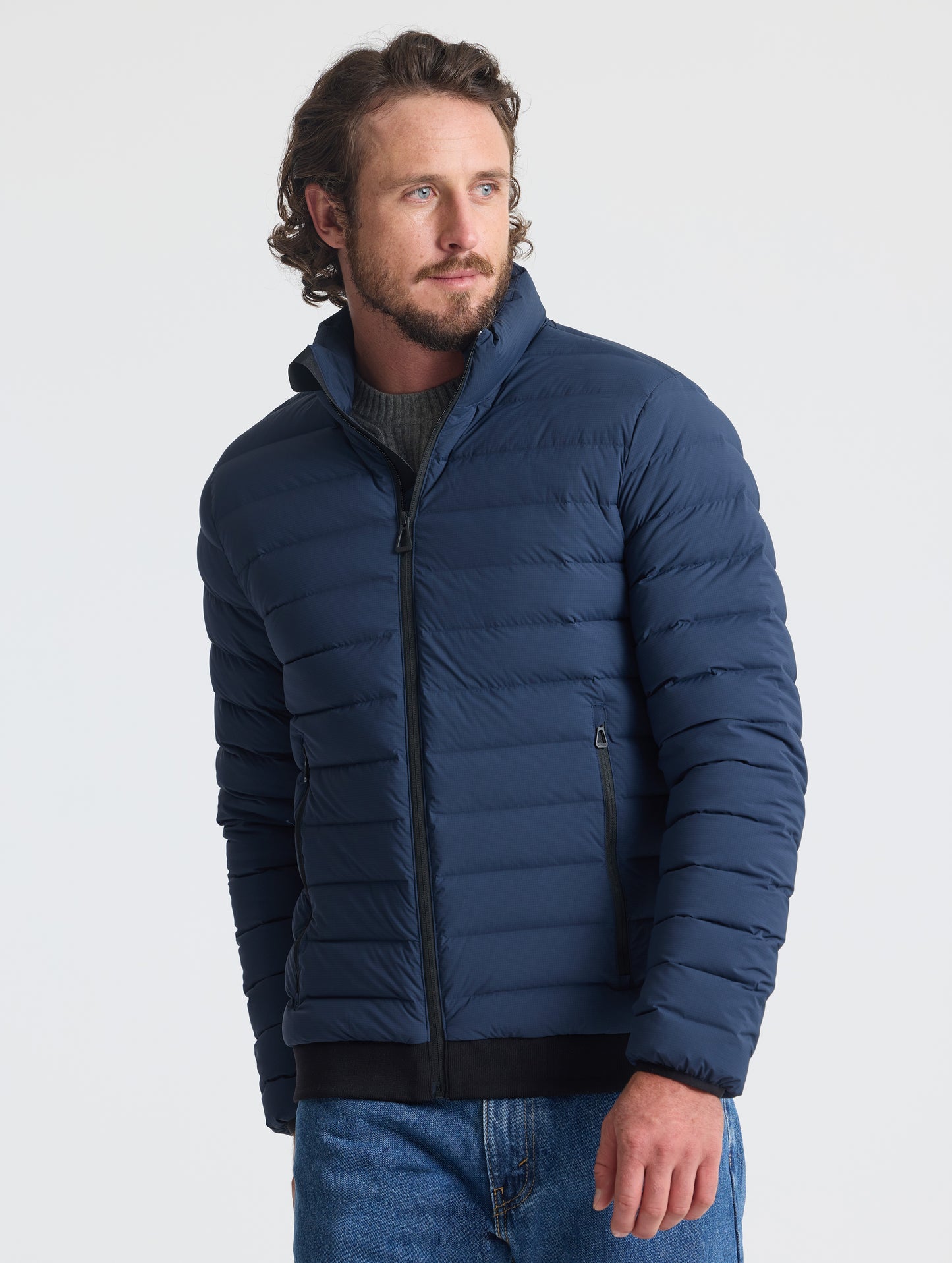 Front view of man wearing Launch Jacket in Total Eclipse dark blue from AETHER Apparel.