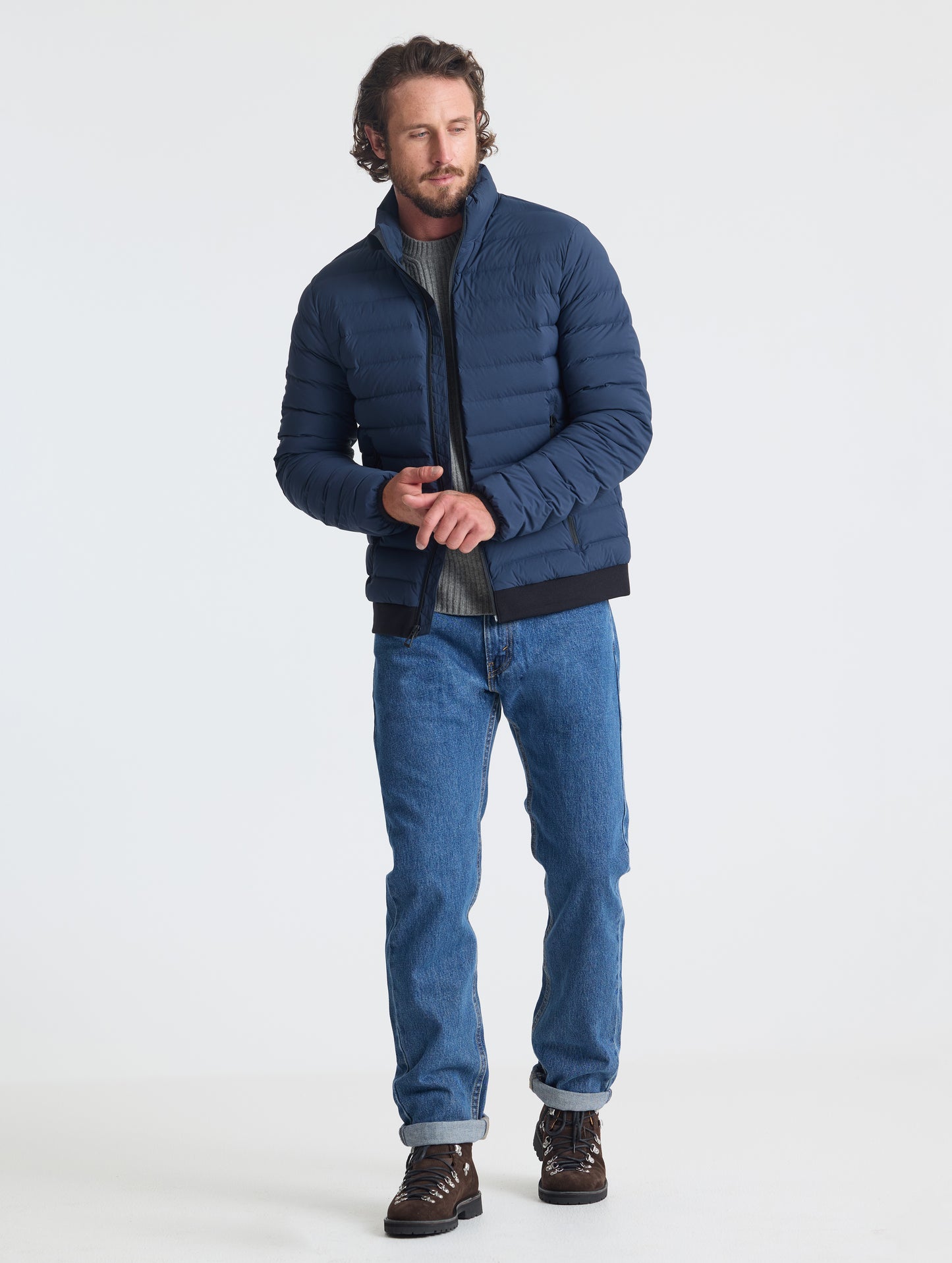 Full body view of man wearing Launch Jacket in Total Eclipse dark blue from AETHER Apparel.
