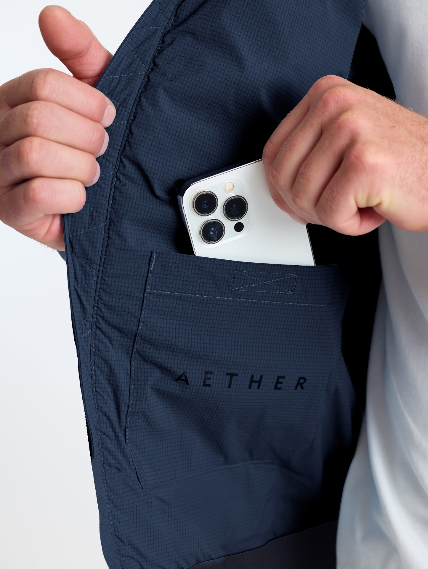 Closeup view of wearer's interior right drop pocket of Launch Jacket in Total Eclipse dark blue from AETHER Apparel.