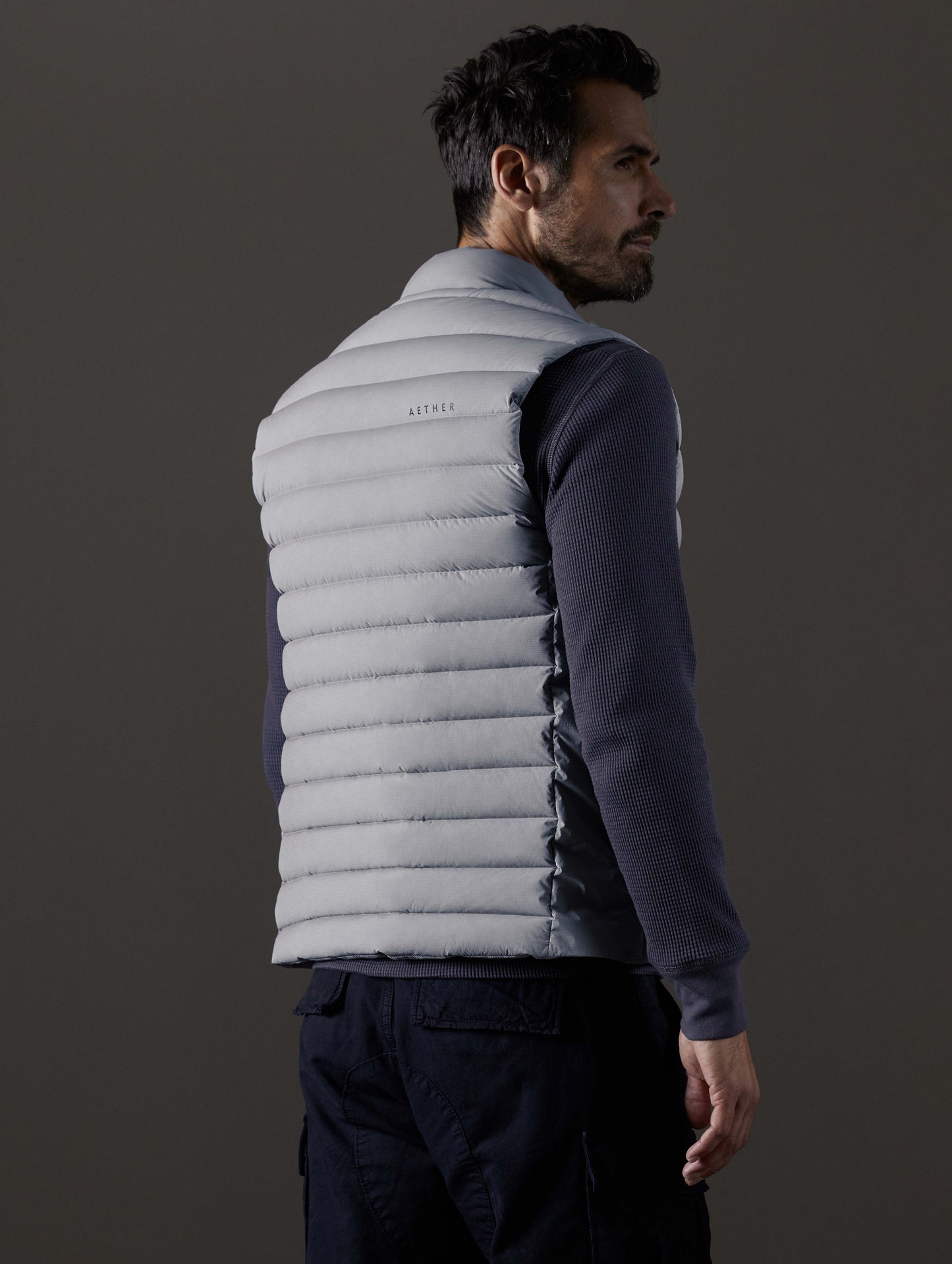 Rear 3/4 body view of man wearing Launch Vest in Sky Grey from AETHER Apparel.