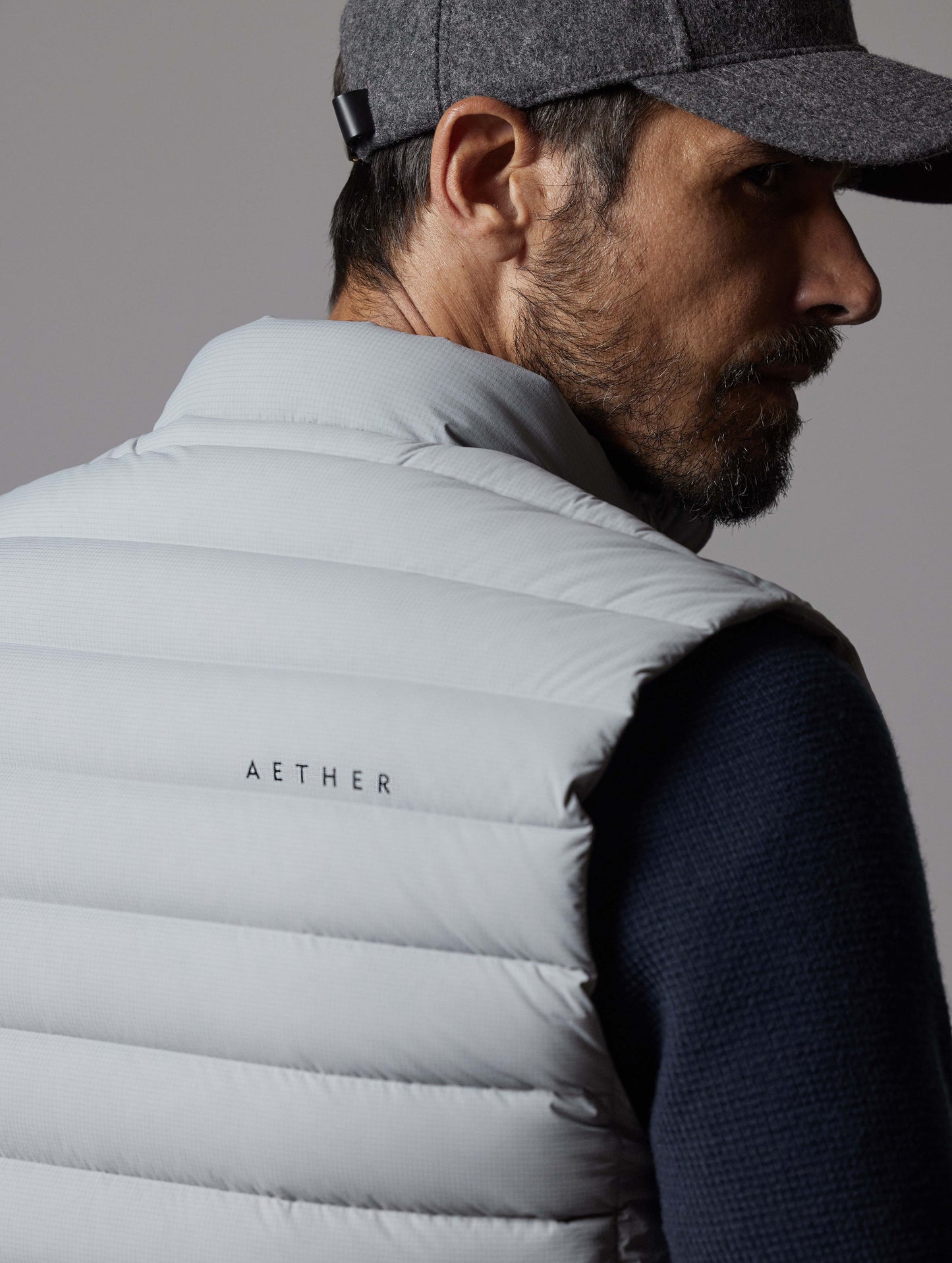 Closeup rear view of shoulder of man wearing Launch Vest in Sky Grey from AETHER Apparel.