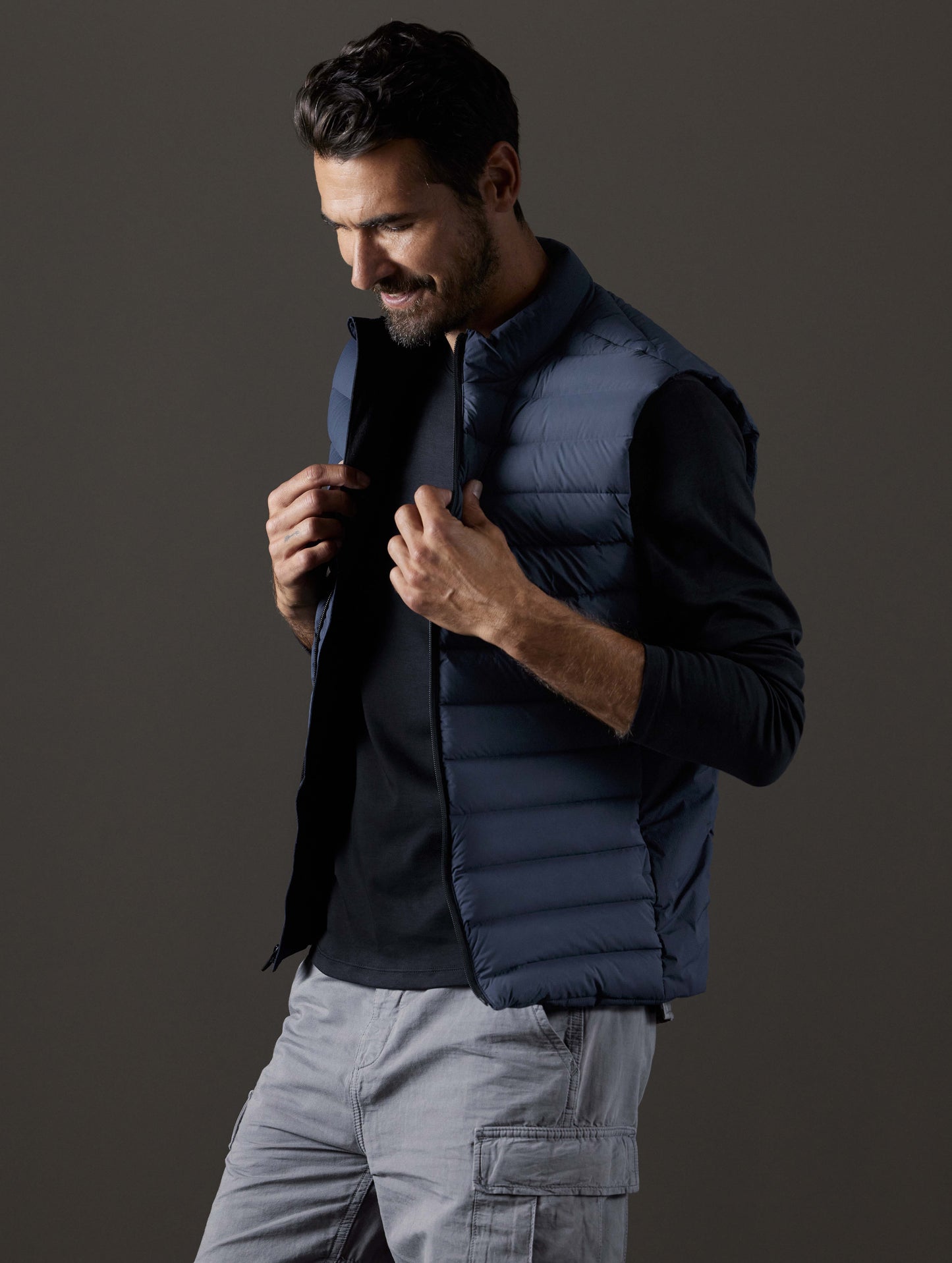 Front 3/4 body view of man wearing Launch Vest in Total Eclipse dark blue from AETHER Apparel.