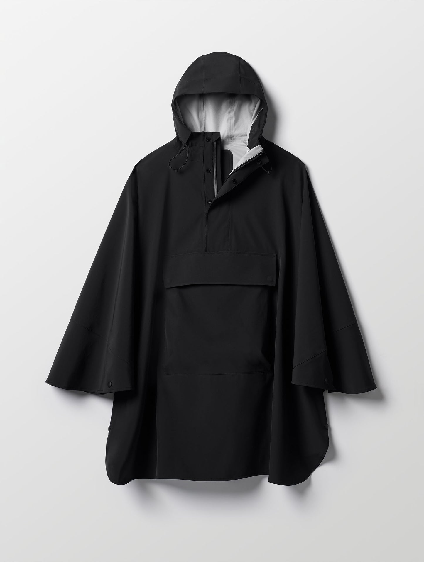 Flat lay of the Line Poncho in Onyx Black from AETHER Apparel.