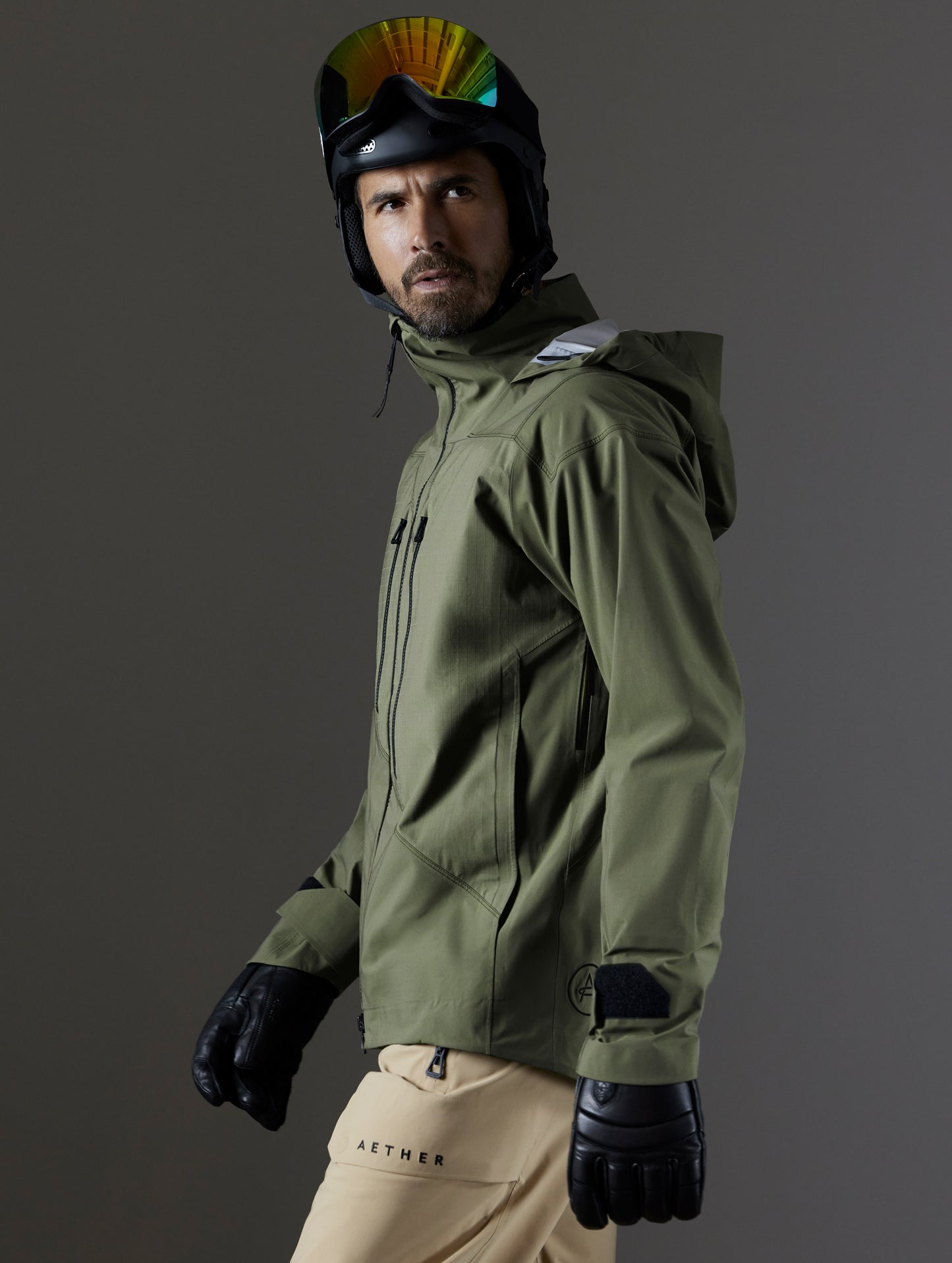 Side profile body view of man wearing Maverick Snow-Shell Jacket in Fern Green from AETHER Apparel.